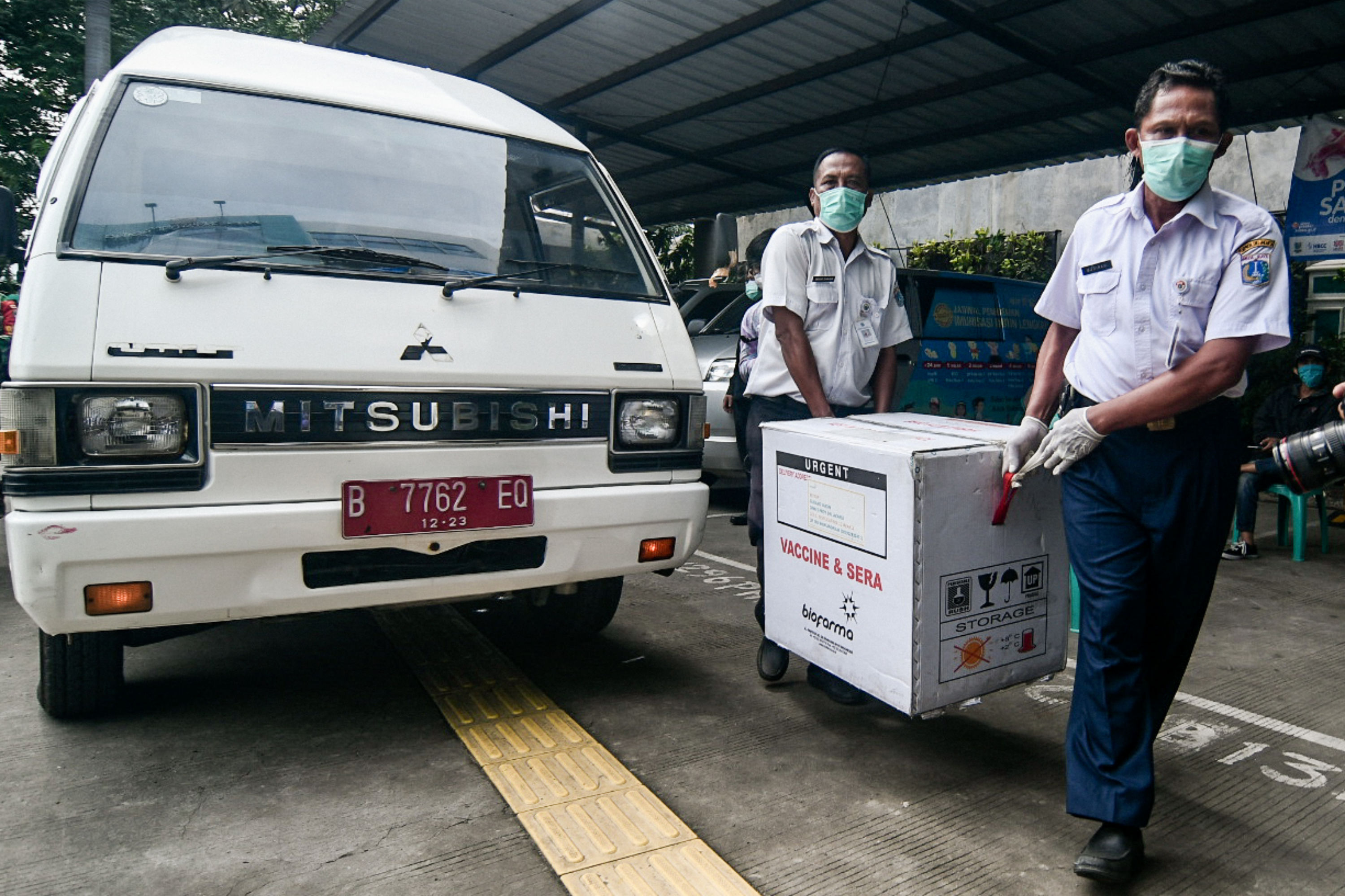 Petugas kesehatan membawa kotak berisi vaksin covid-19 buatan Sinovac Biotech Ltd. di Puskesmas Cilincing, Jakarta, Rabu (13/1)