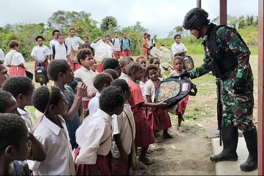Satgas Pamtas Yonif Mekanis 403/Wirasada Pratista bagi tas sekolah di SD Inpres Dimbalib, Kp Serambakon, Distrik Serambakon, Papua.