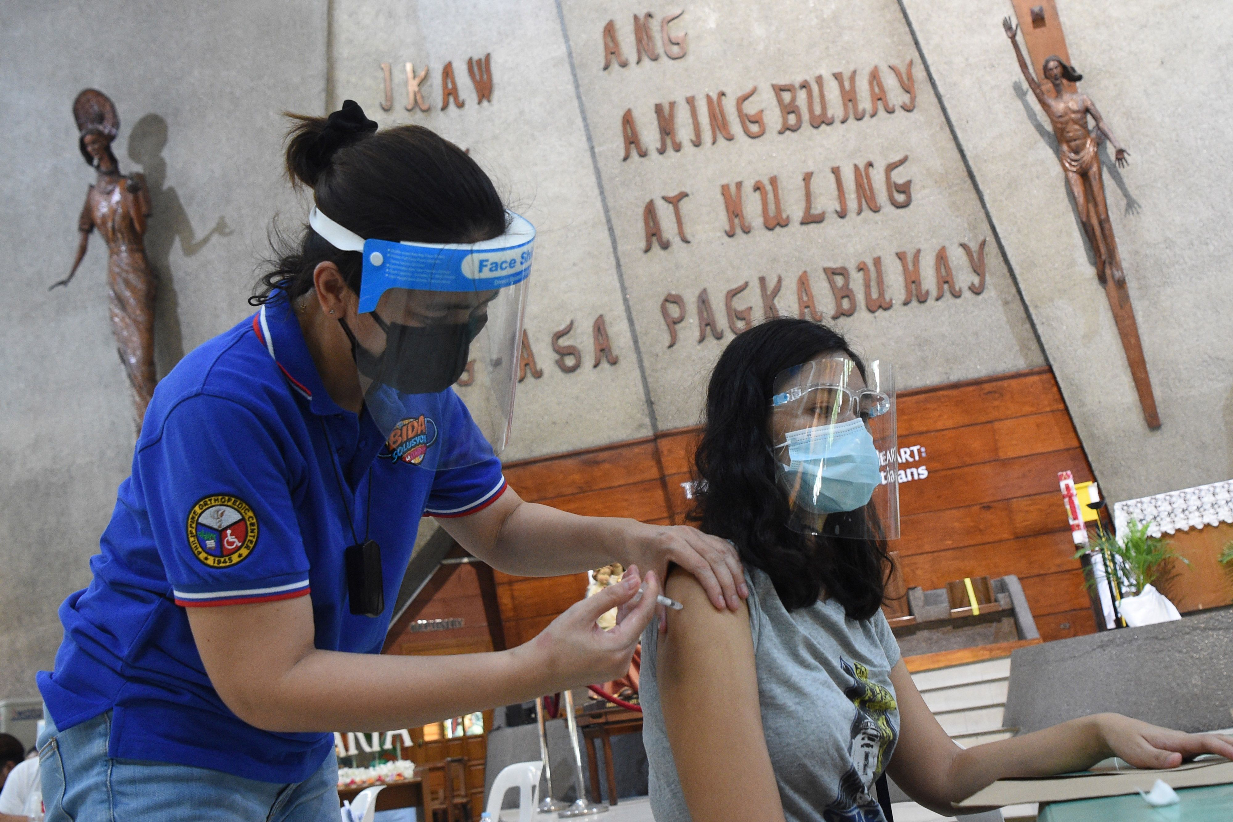 Petugas medis menyuntikkan vaksin covid-19 kepada warga di Manila, Filipina.