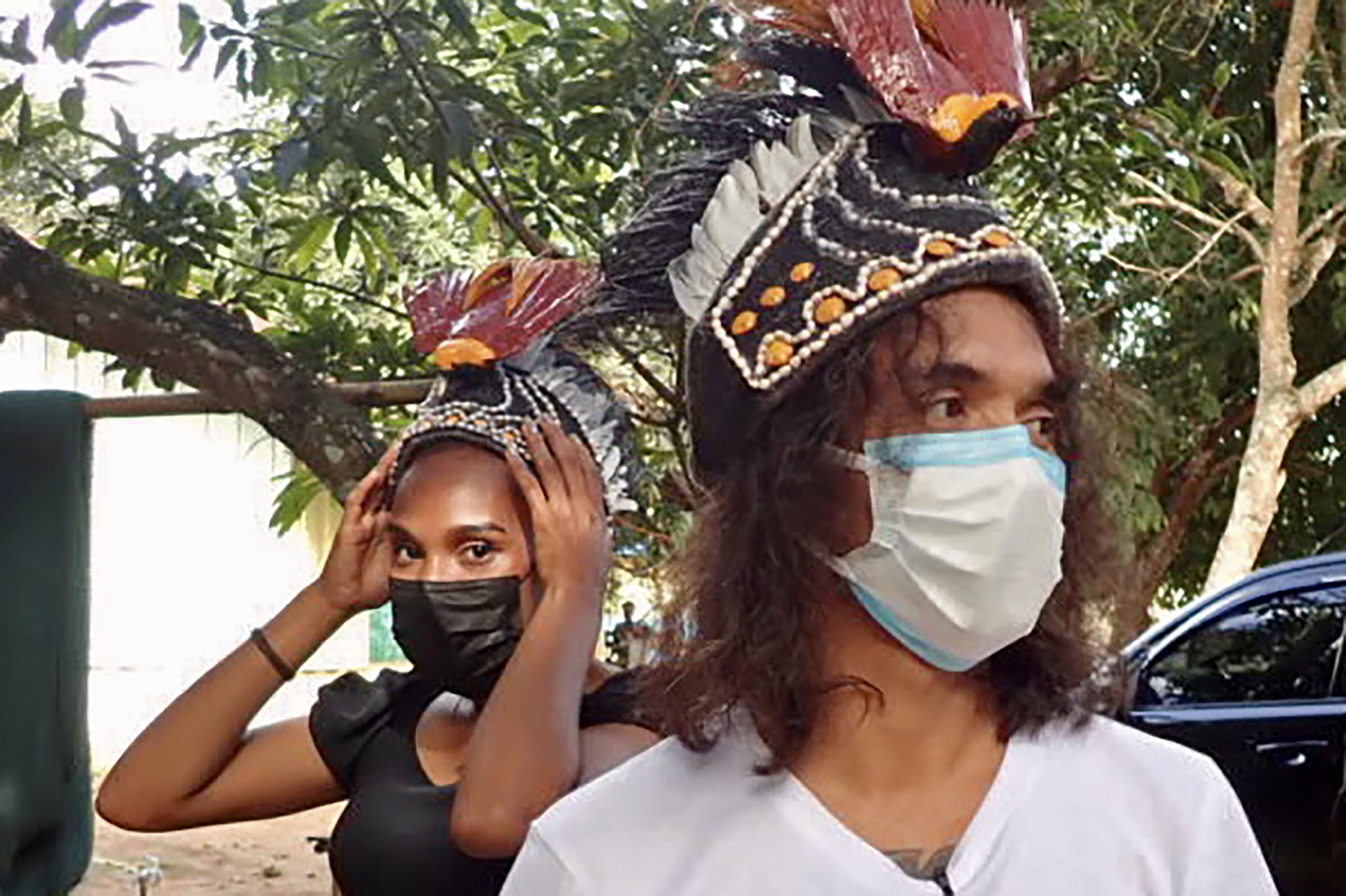 Kaka Slank (kanan) mengenakan topi cendrawasih terbuat dari sabut dan daun kelapa di Desa Waninggap Nanggo, Merauka, Papua.