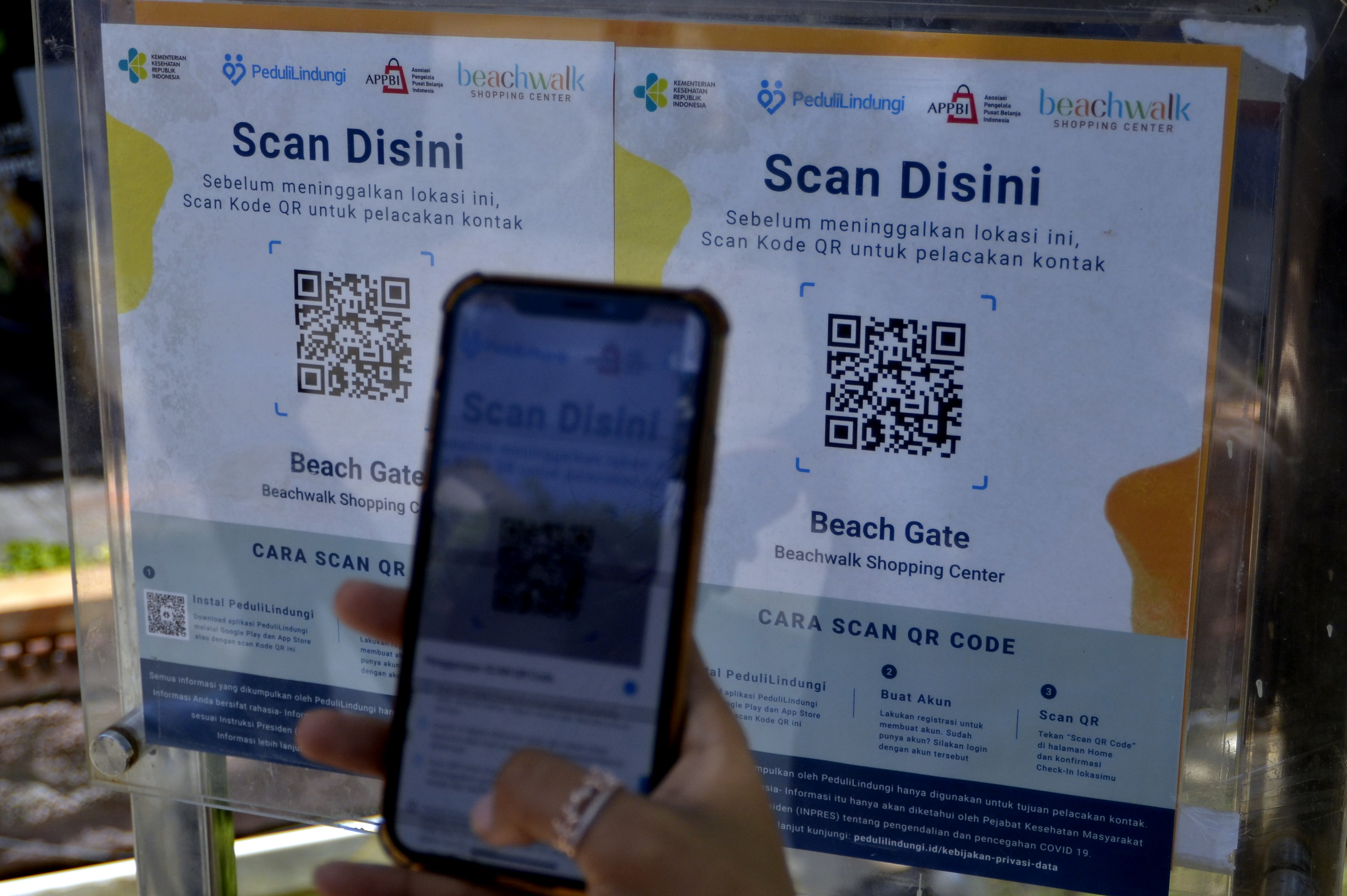 Pengunjung memindai QR Code dengan aplikasi PeduliLindungi 