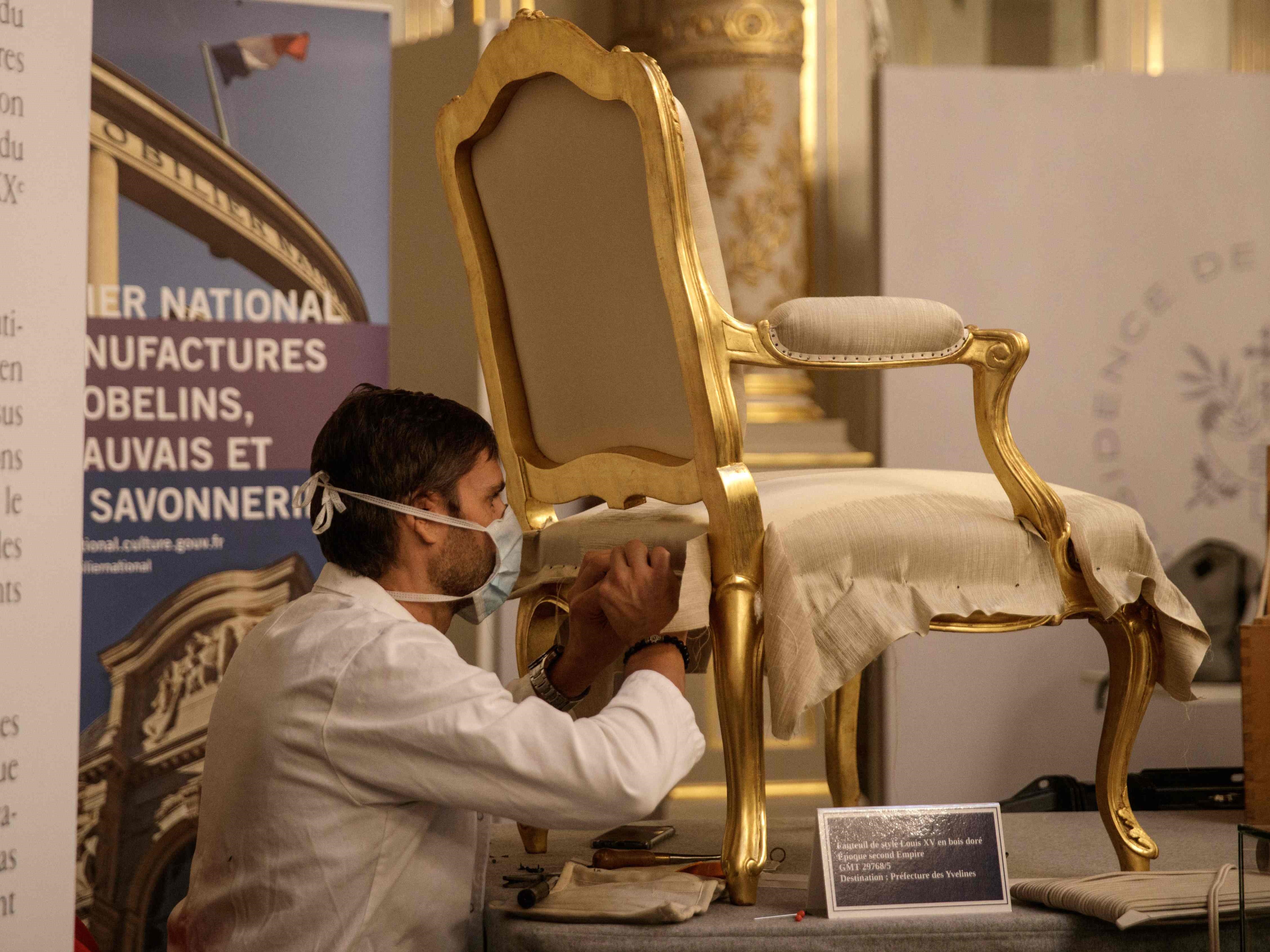 Seorang pekerja merestorasi kursi di Istana Elysee di Paris, Prancis.