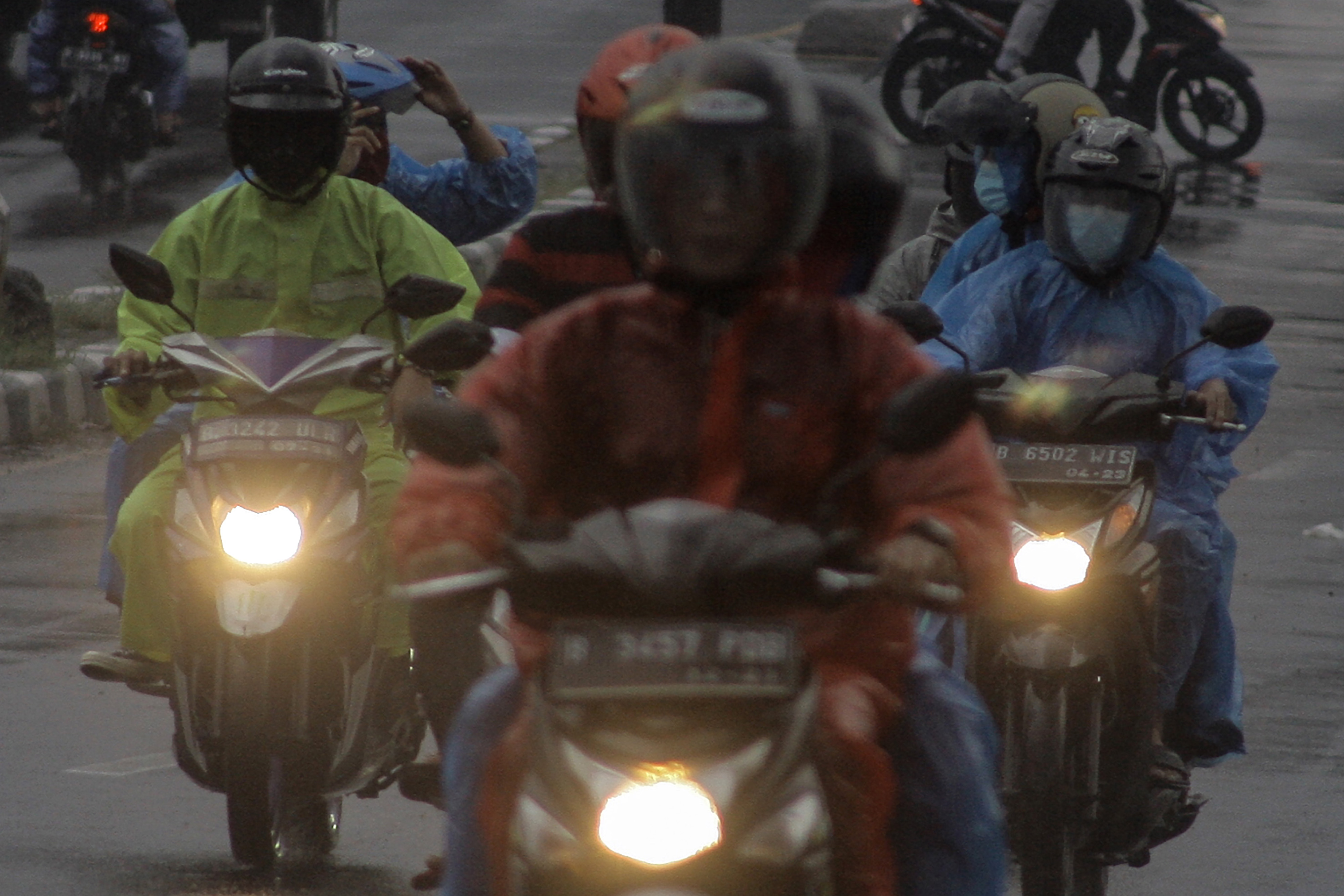  Pengendara sepeda motor melintas saat hujan di Jalan Raya Bogor, Cibinong, Kabupaten Bogor, Jawa Barat, Minggu (1/8/2021)