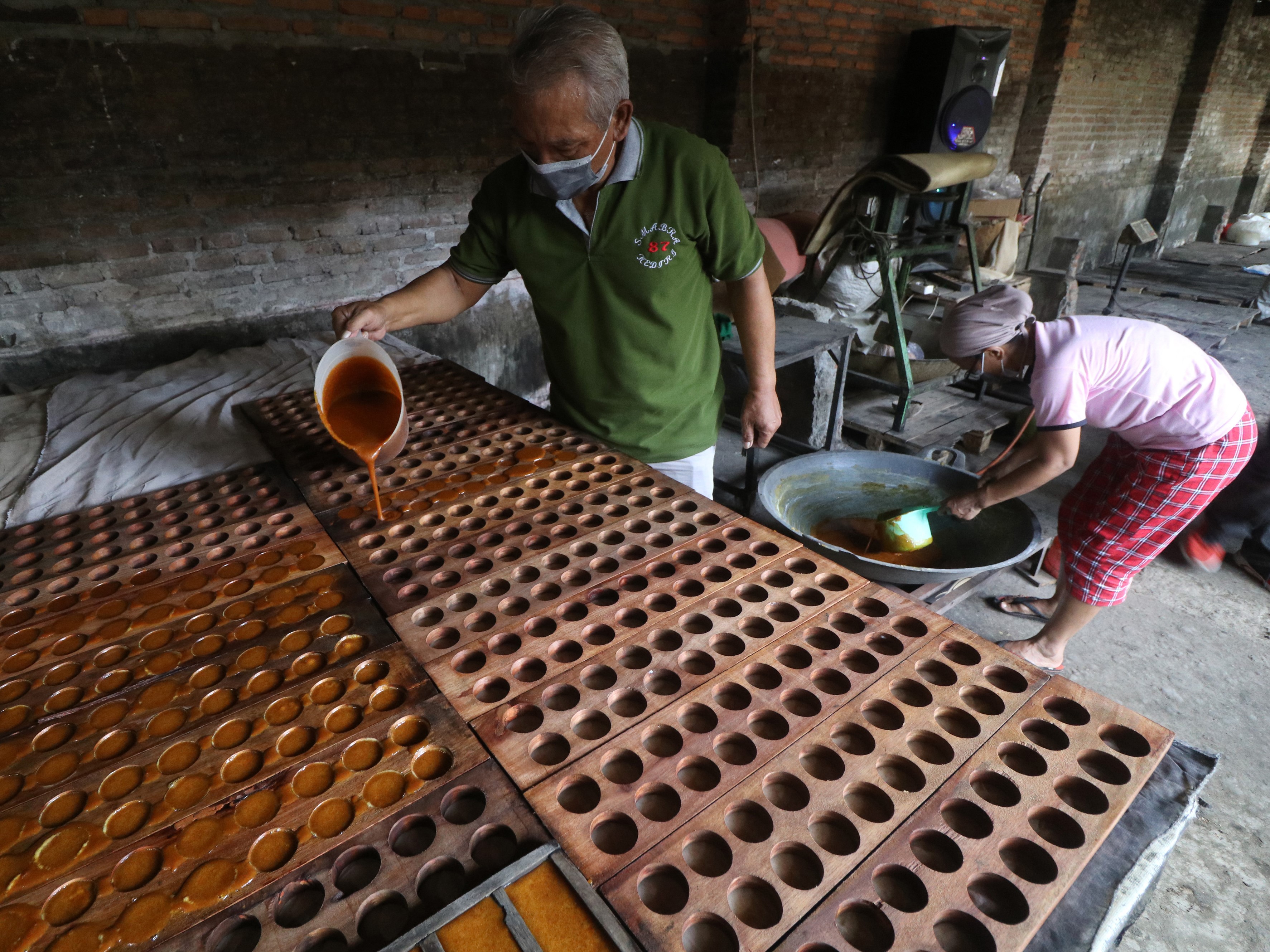 Perajin mencetak gula merah berukuran kecil di Desa Nambaan, Kediri, Jawa Timur, Jumat (3/9).