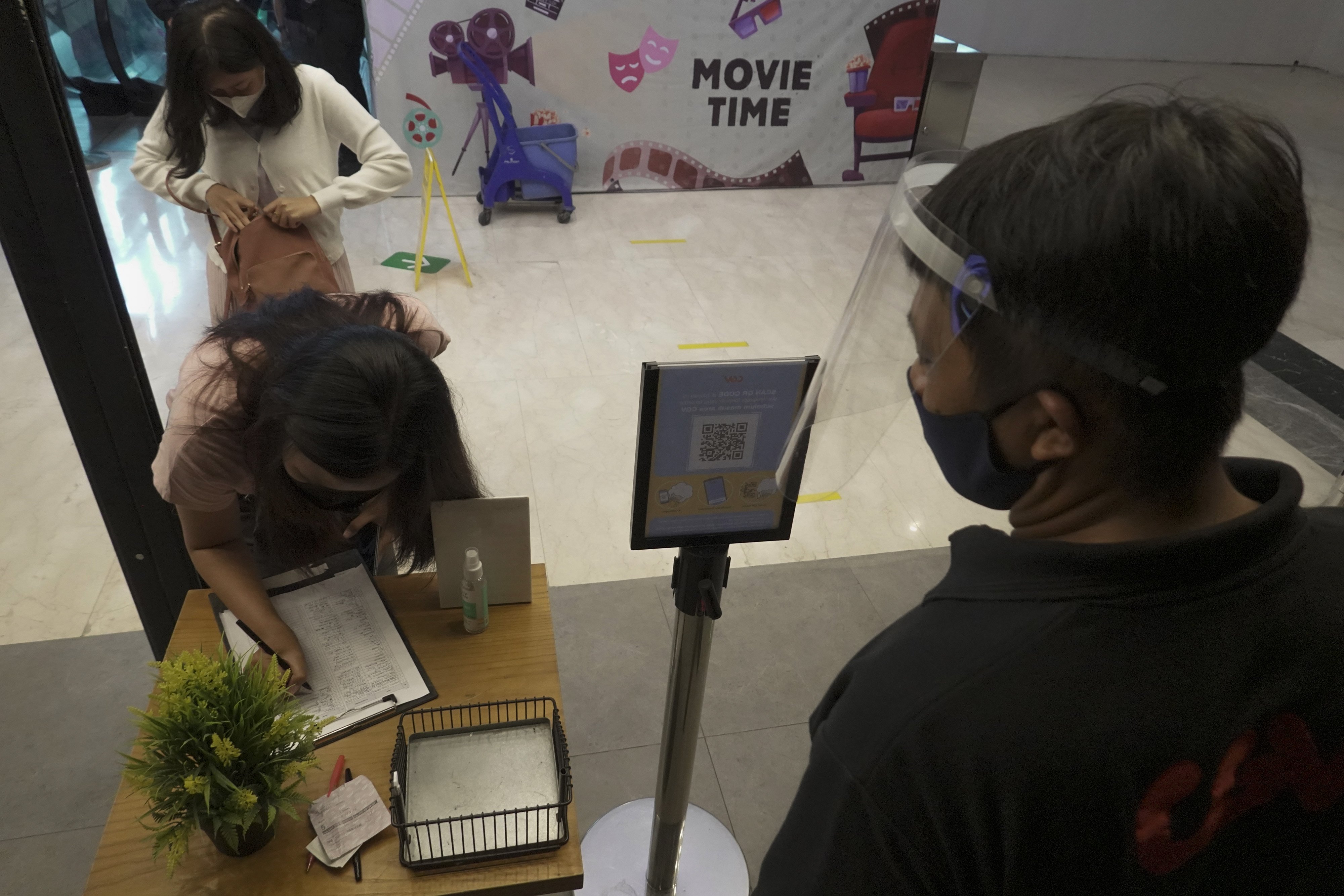  Penonton mengisi data identitas dan nomor kontak sebelum memasuki Bioskop CGV di Rita Supermall Purwokerto, Banyumas, Jateng, Sabtu (3/4).