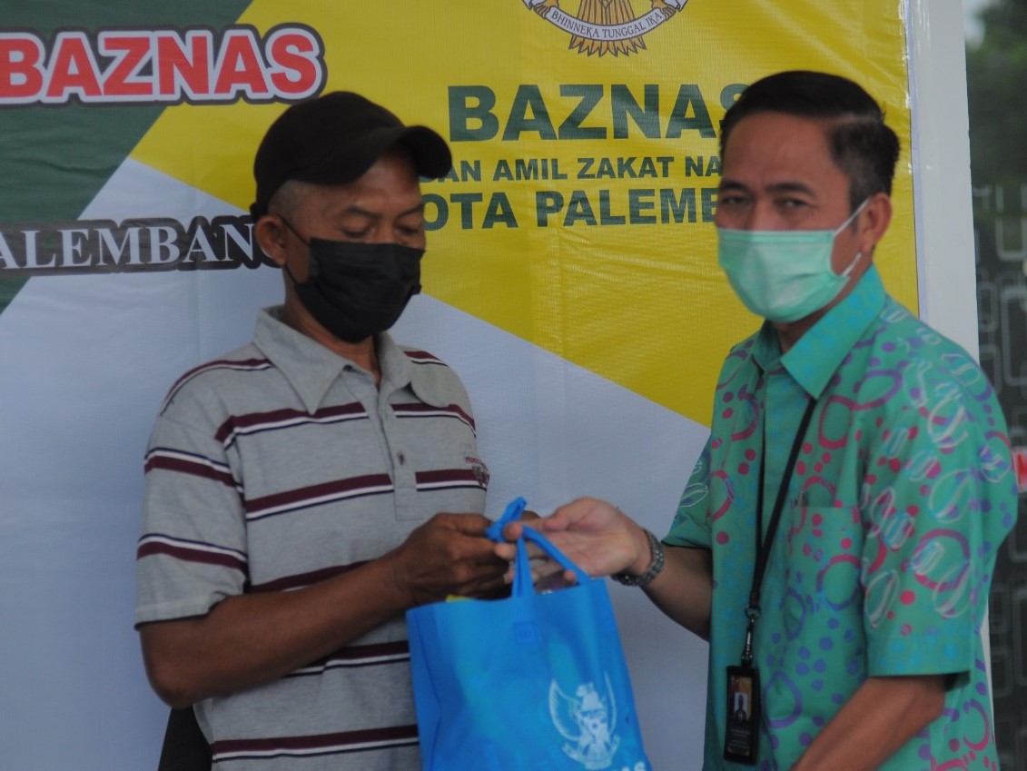 Sekda Palembang Ratu Dewa menyerahkan bantuan kepada para penggali kubur di masa pandemi, Kamis (30/9).