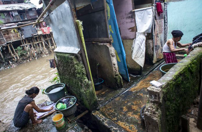 Warga mencuci pakaian di toilet umum yang dibangun di bantaran Sungai Ciliwung, Jakarta, Rabu (21/11/2018)