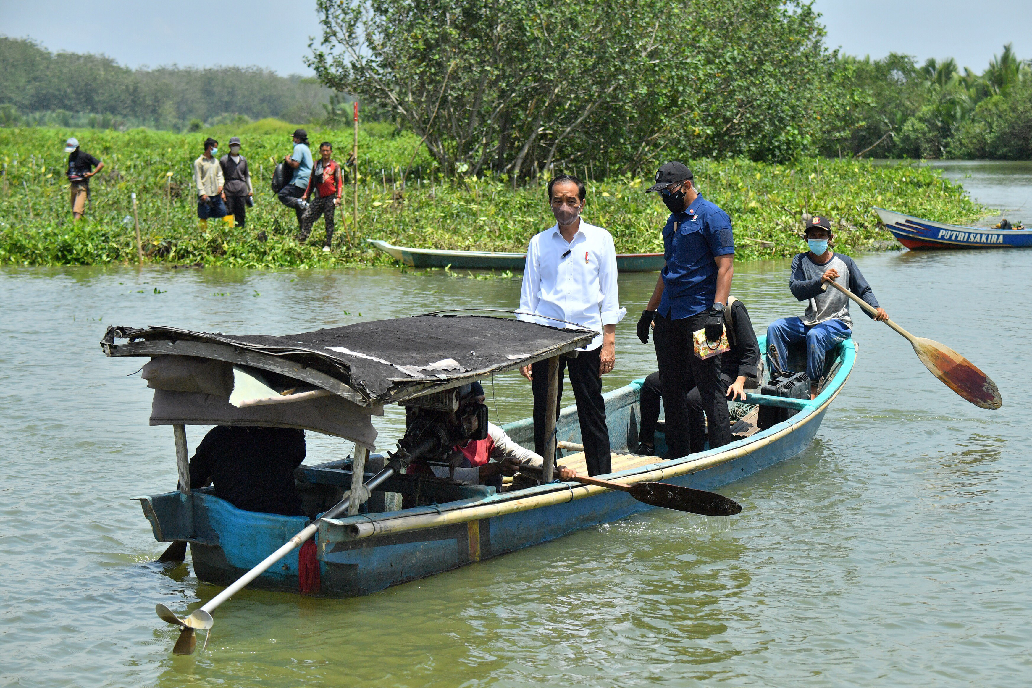 Presiden Jokowi menggunakan perahu saat melakukan penanaman Mangrove di Desa Tritih Kulon, Cilacap Utara, Cilacap, Jateng, Kamis (23/9). 