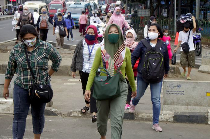 Pejalan kaki memakai masker melintas di kawasan Pasar Minggu, Jakarta, Kamis (28/5/2020).
