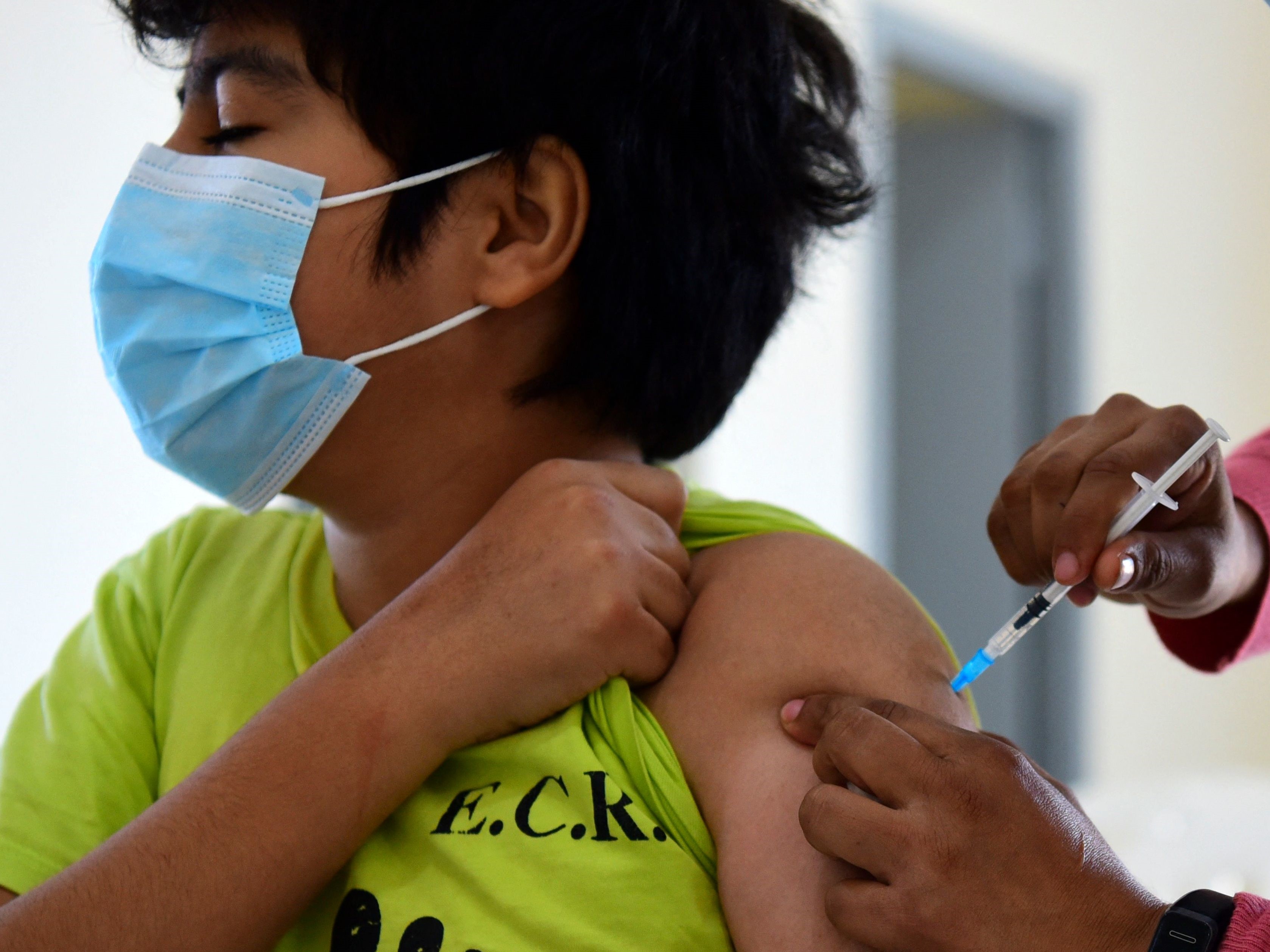 Anak di bawah umur menerima dosis vaksin Pfizer-BioNTech melawan covid-19 di pusat vaksinasi Asuncion, Paraguay.