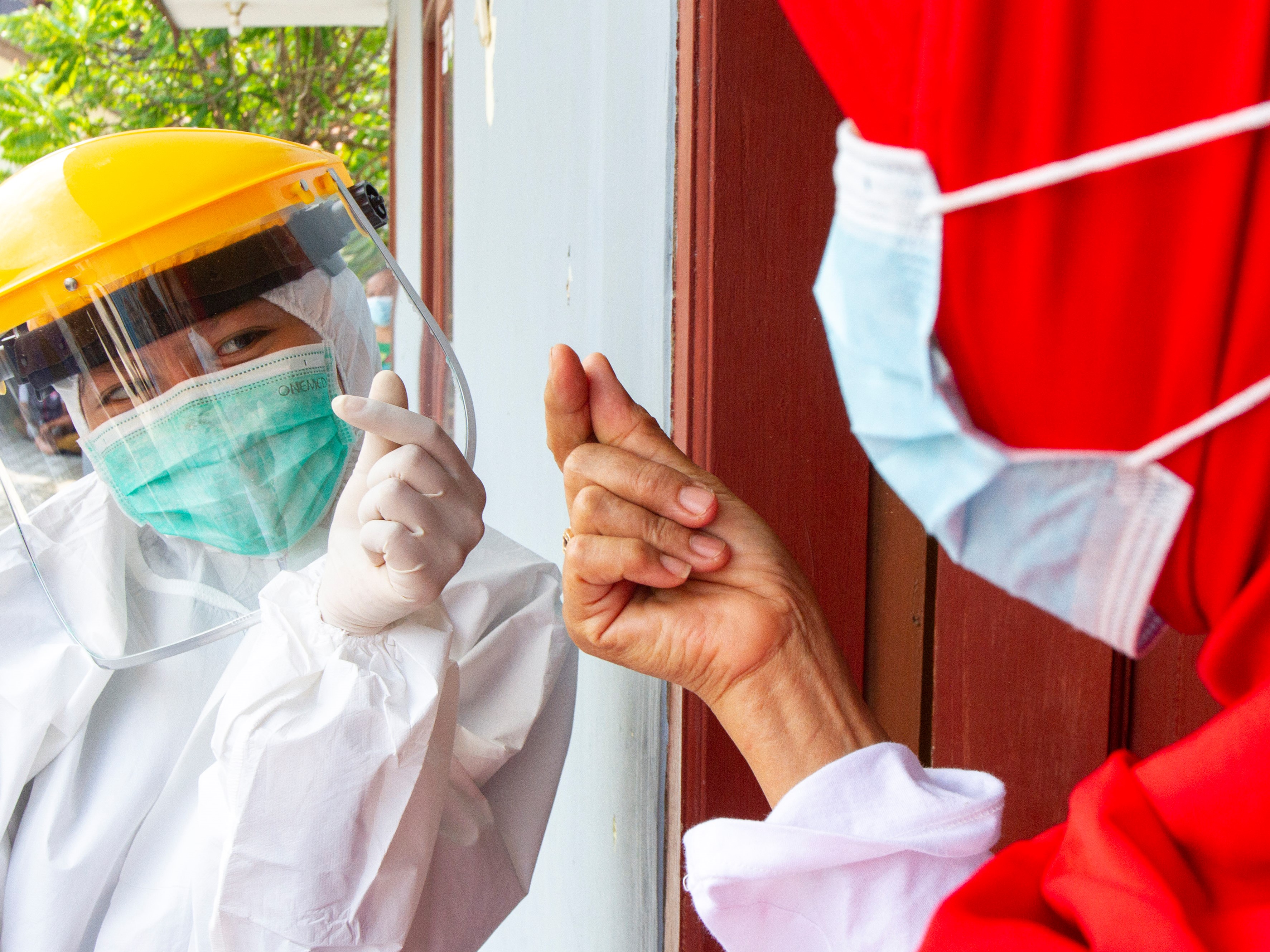 Tenaga kesehatan memberikan simbol semangat finger heart kepada pasien yang telah dinyatakan sembuh dari covid-19.