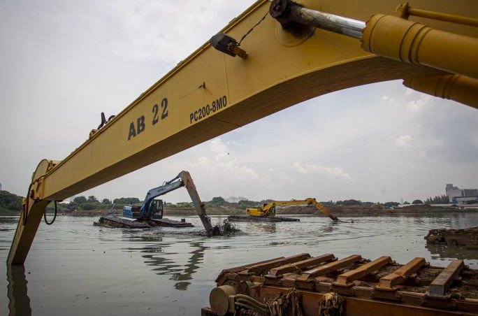 Petugas Dinas Sumber Daya Air (SDA) DKI Jakarta mengoperasikan alat berat untuk mengeruk endapan lumpur di Waduk Ria Rio, Jakarta.
