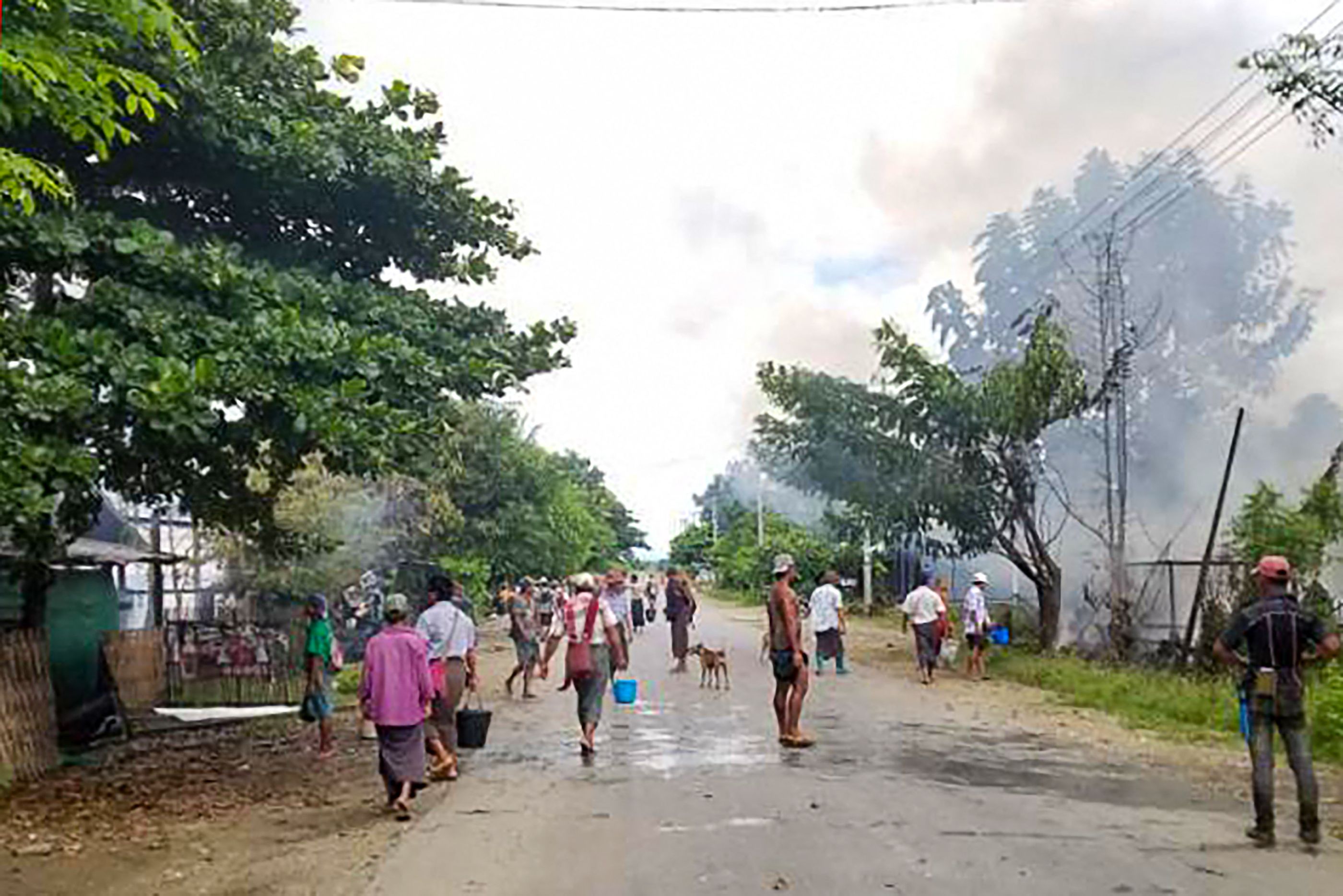 Warga berusaha memadamkan sebuah rumah yang terbakar akibat bentrokan antara pasukan pemberontak dan militer Myanmar.