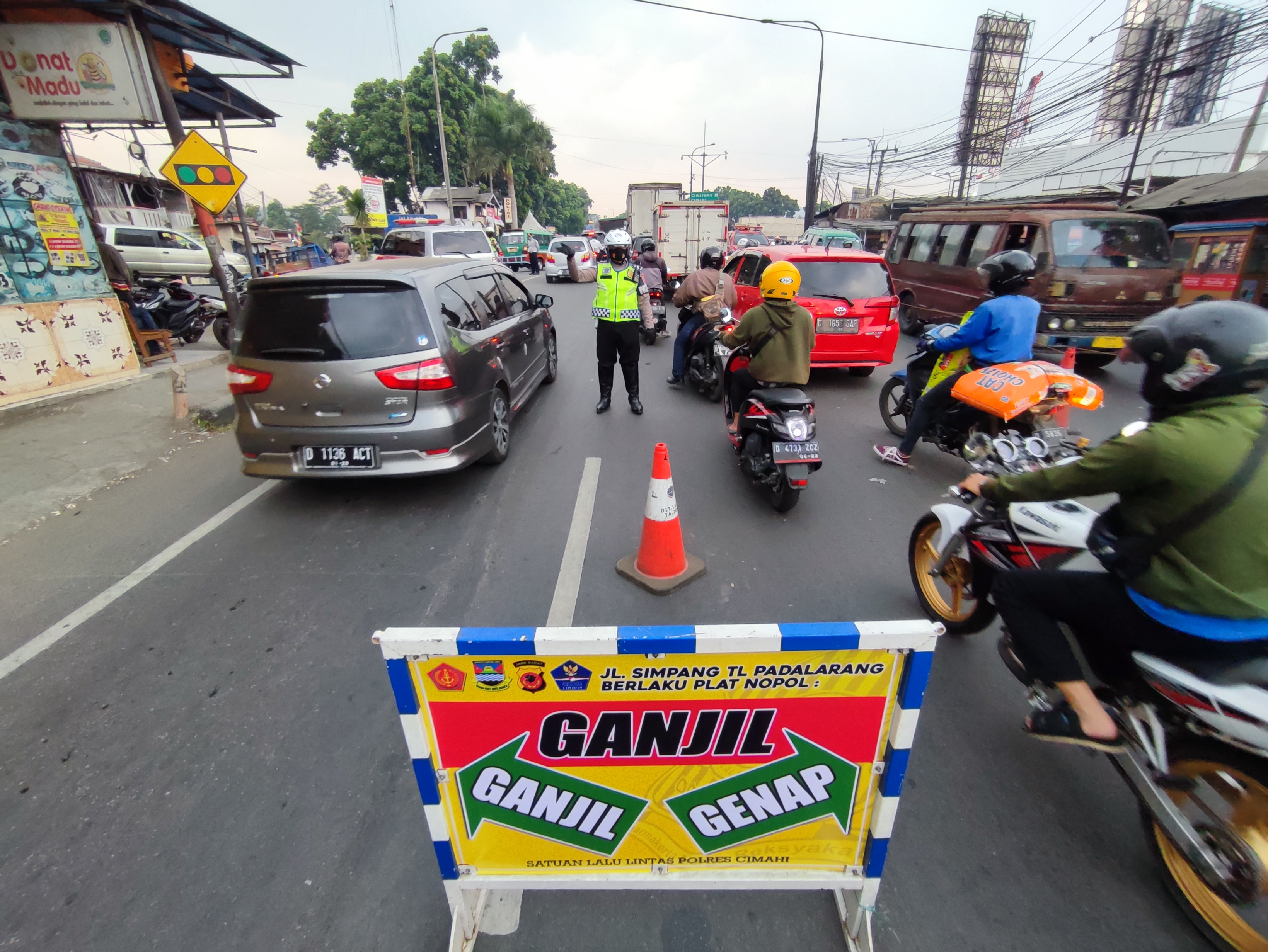  Polisi mengatur kendaraan saat pemberlakuan sistem ganjil genap di Padalarang, Kabupaten Bandung Barat, Jumat (3/9) sore.