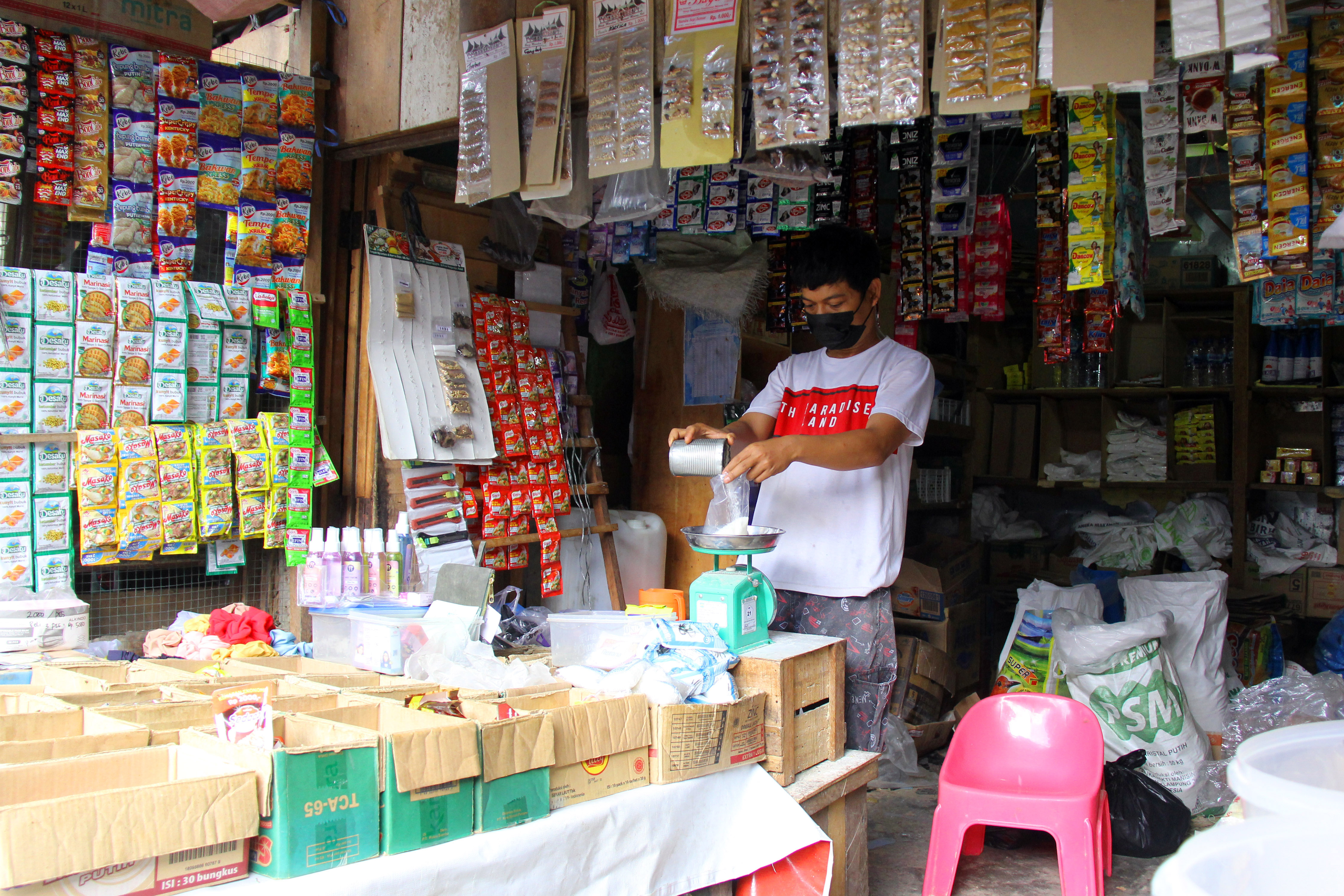 Seorang pedagang sembako menimbang gula pasir di Pasar Pulo Payung, Dumai, Riau.