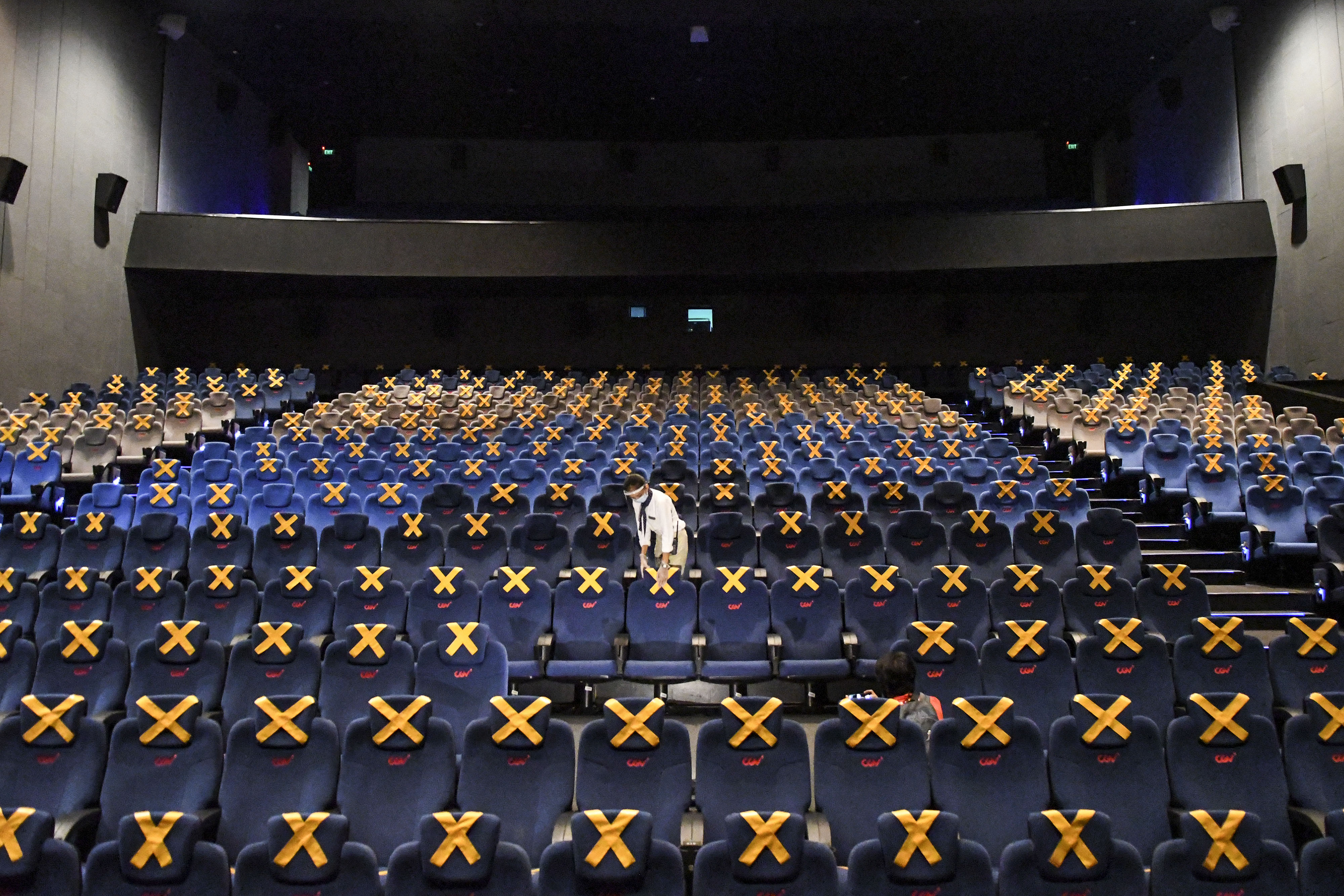 Petugas memeriksa tempat duduk di salah satu studio bioskop di Jakarta.