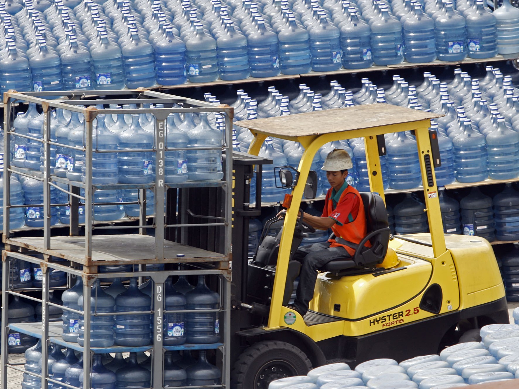 Pekerja mengatur tumpukan galon air minum isi ulang di pusat pengisian di kawasan Kalibata, Jakarta Selatan.