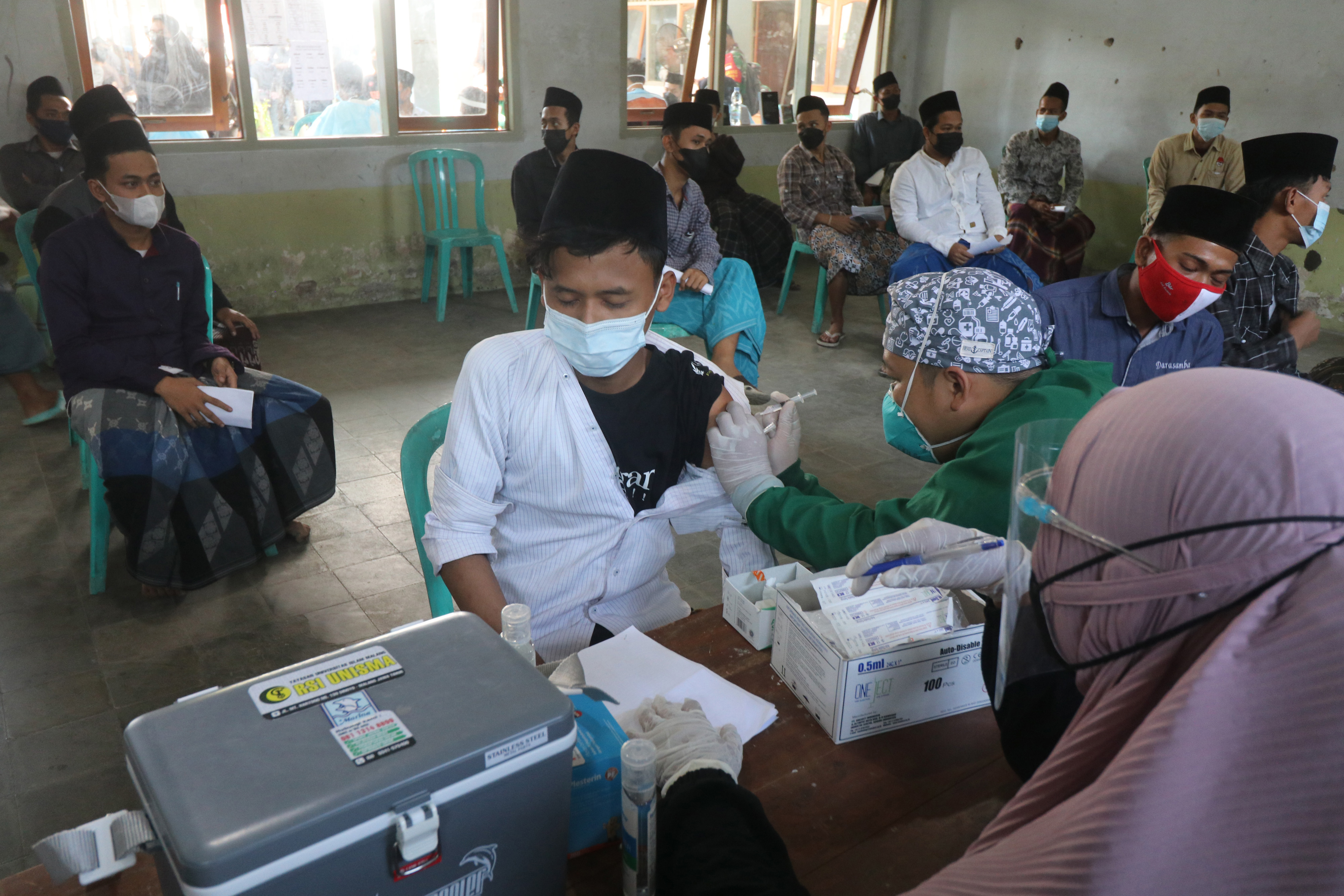  VAKSINASI DI PONPES LIRBOYO: Petugas kesehatan menyuntikkan vaksin covid-19 kepada santri Pondok Pesantren Lirboyo, Kediri, Jawa Timur.