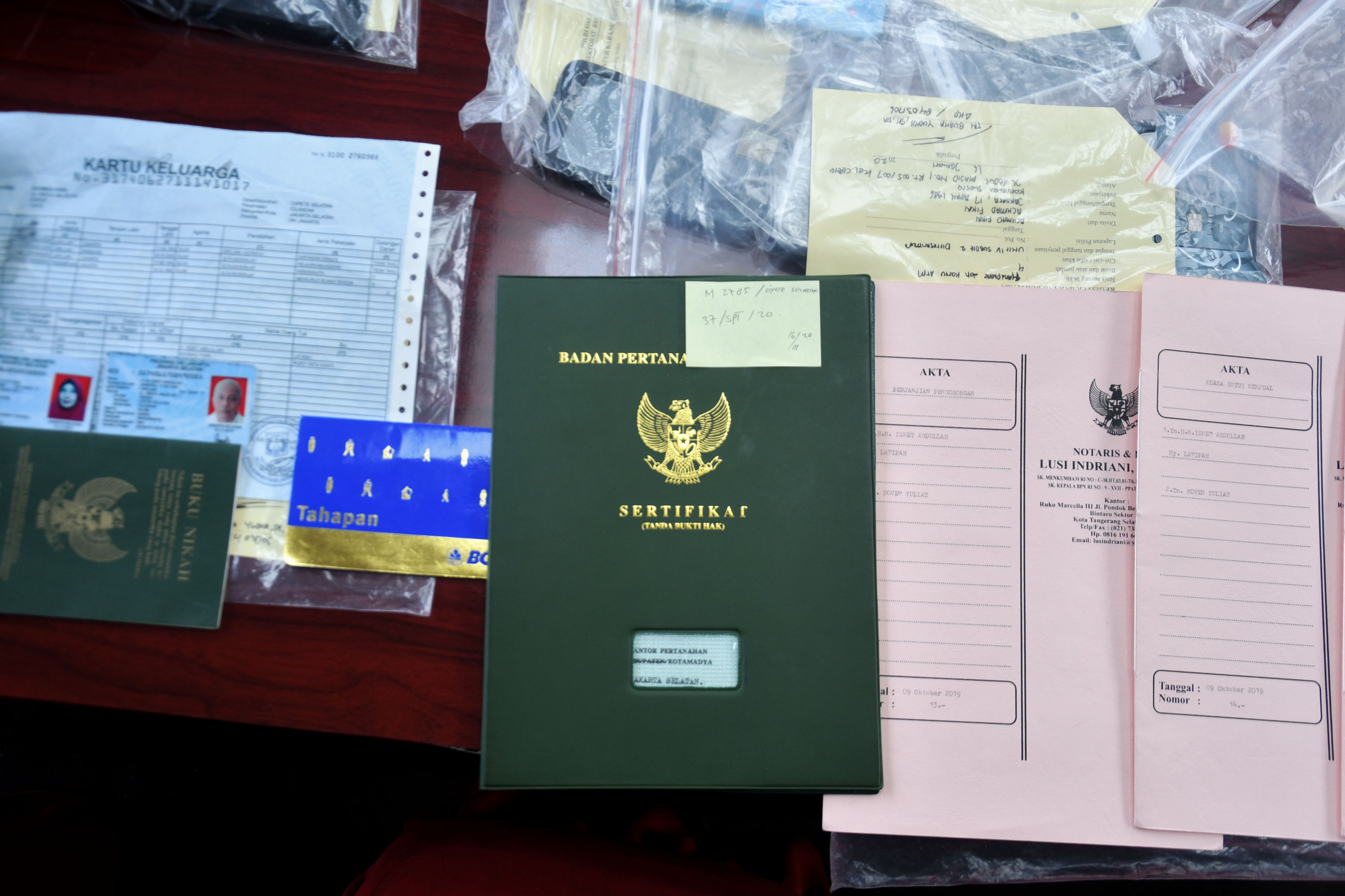 Ilustrasi petugas kepolisian menunjukkan barang bukti kasus pemalsuan sertifikat tanah.