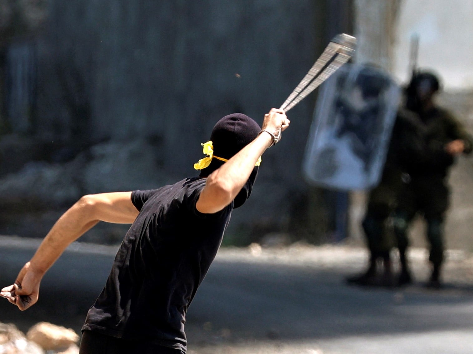 Seorang demonstran Palestina menggunakan ketapel untuk melemparkan batu ke arah pasukan keamanan Israel, Jumat (3/9).