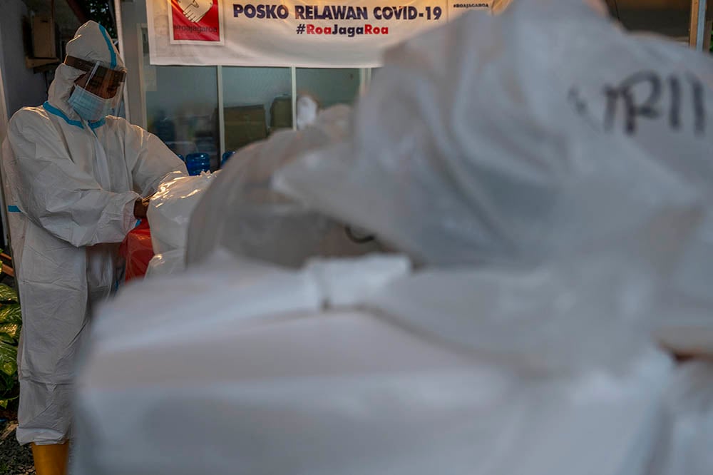 Relawan #RoaJagaRoa menyiapkan bungkusan makanan untuk diantarkan kepada warga yang isolasi mandiri COVID-19 di Palu. 