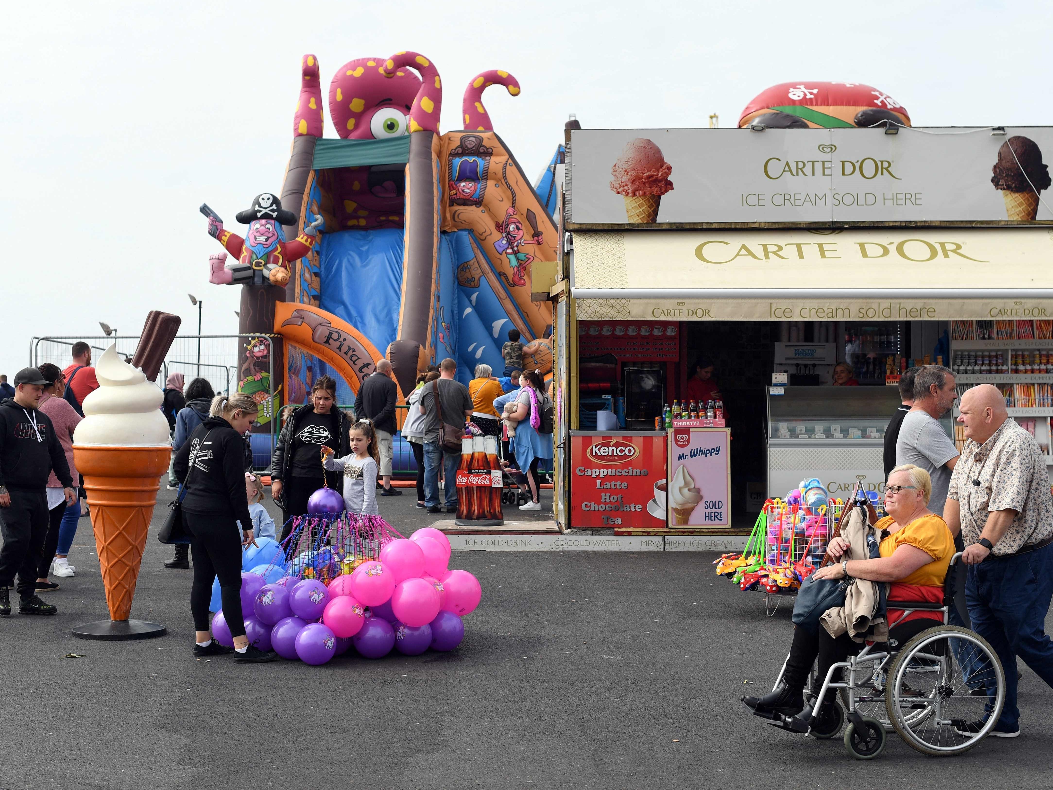 Orang-orang berjalan-jalan di sepanjang kawasan pejalan kaki di Blackpool, barat laut Inggris, 4 September 2021.
