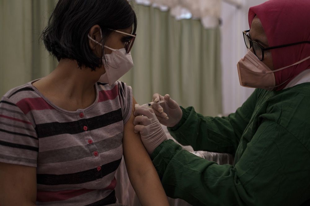 Seorang nakes menyuntikan vaksin covid-19 Moderna kepada penyandnag komorbid di Bogor.