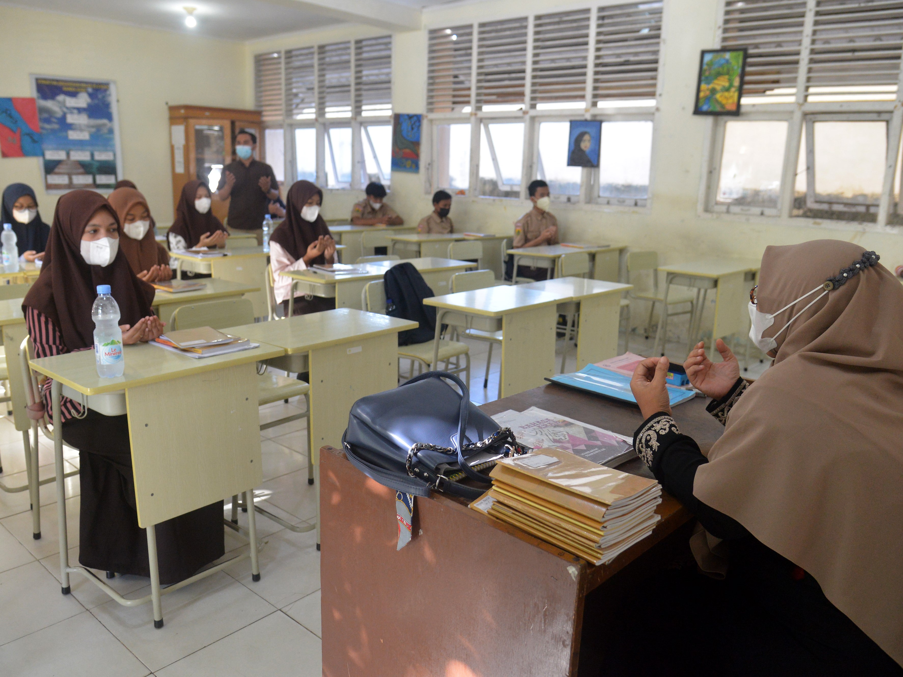 Sejumlah murid berdoa sebelum memulai proses belajar mengajar di MTsN Model, Banda Aceh, Aceh, Jumat (24/9).