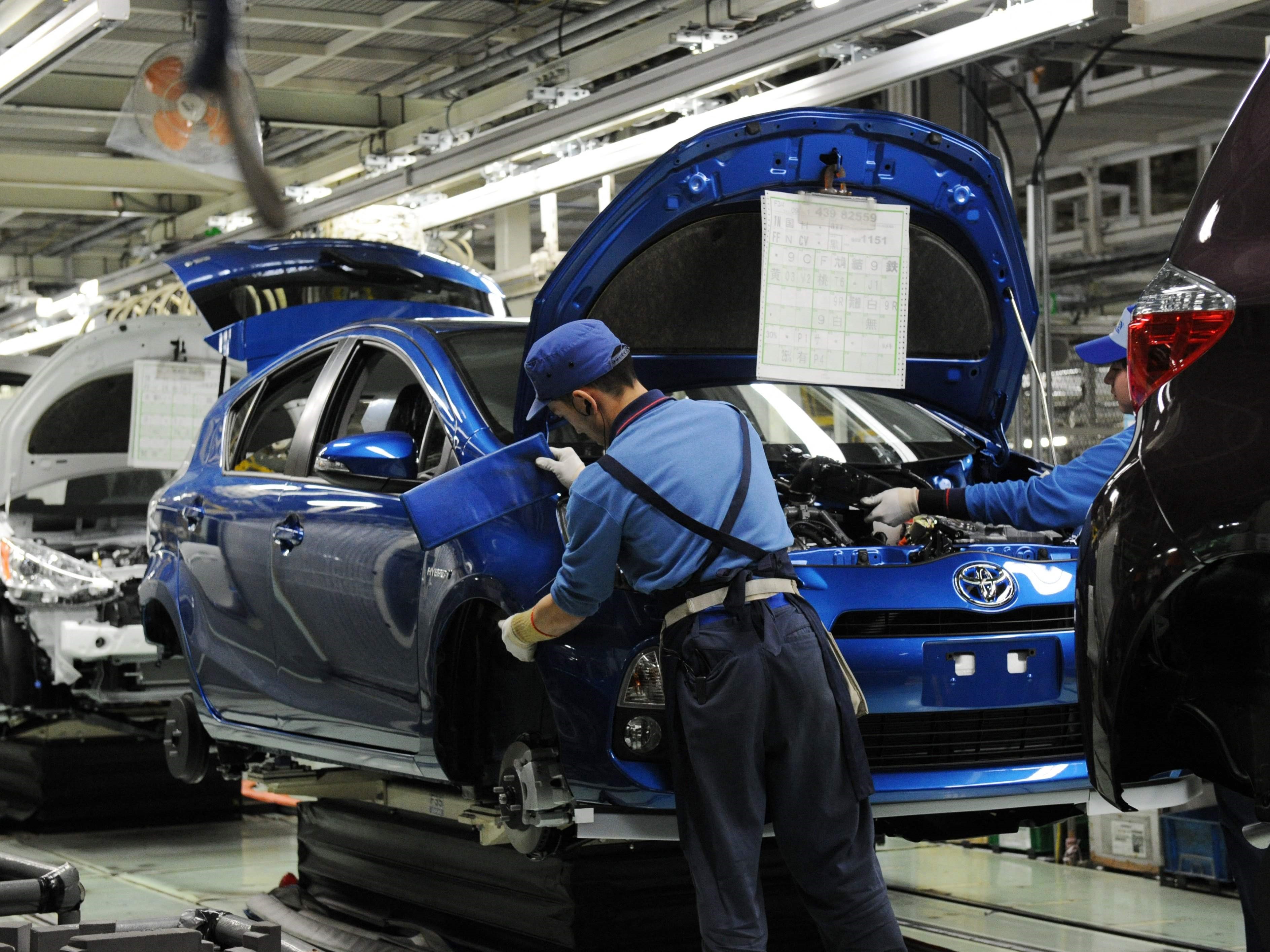 Pekerja merakit bumper depan kendaraan hibrida kompak Toyota Aqua di pabrik Iwate Kanto Auto Works di Kanegasaki, Jepang.