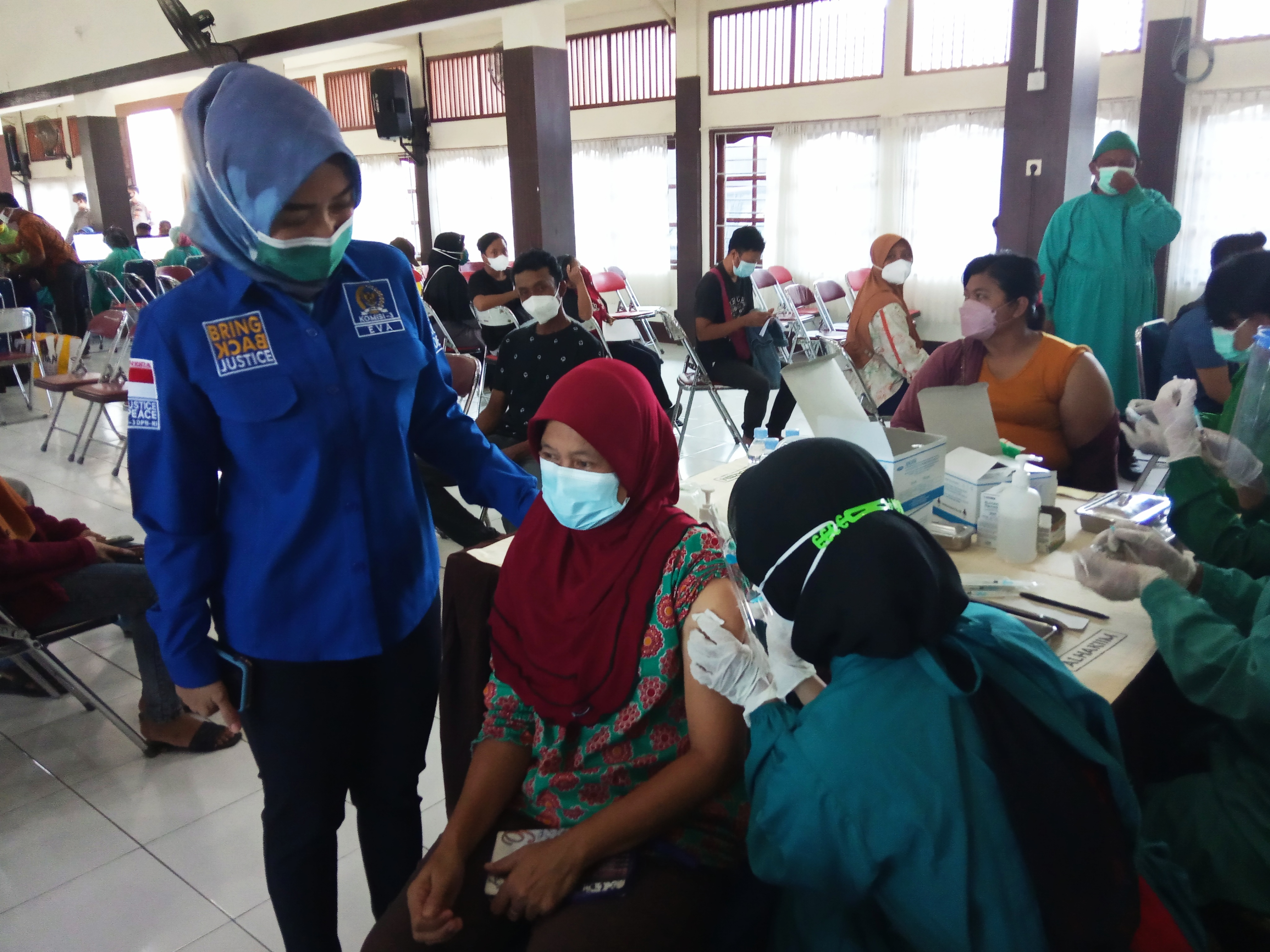 Eva Yuliana saat mendampingi seorang warga Klaten menerima suntikan vaksinasi