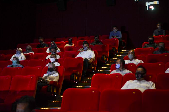 Penonton Bioskop XXI duduk berjaga jarak saat pemeriksaan kesiapan bioskop beroperasi kembali di Pusat Grosir Cililitan, Jakarta.