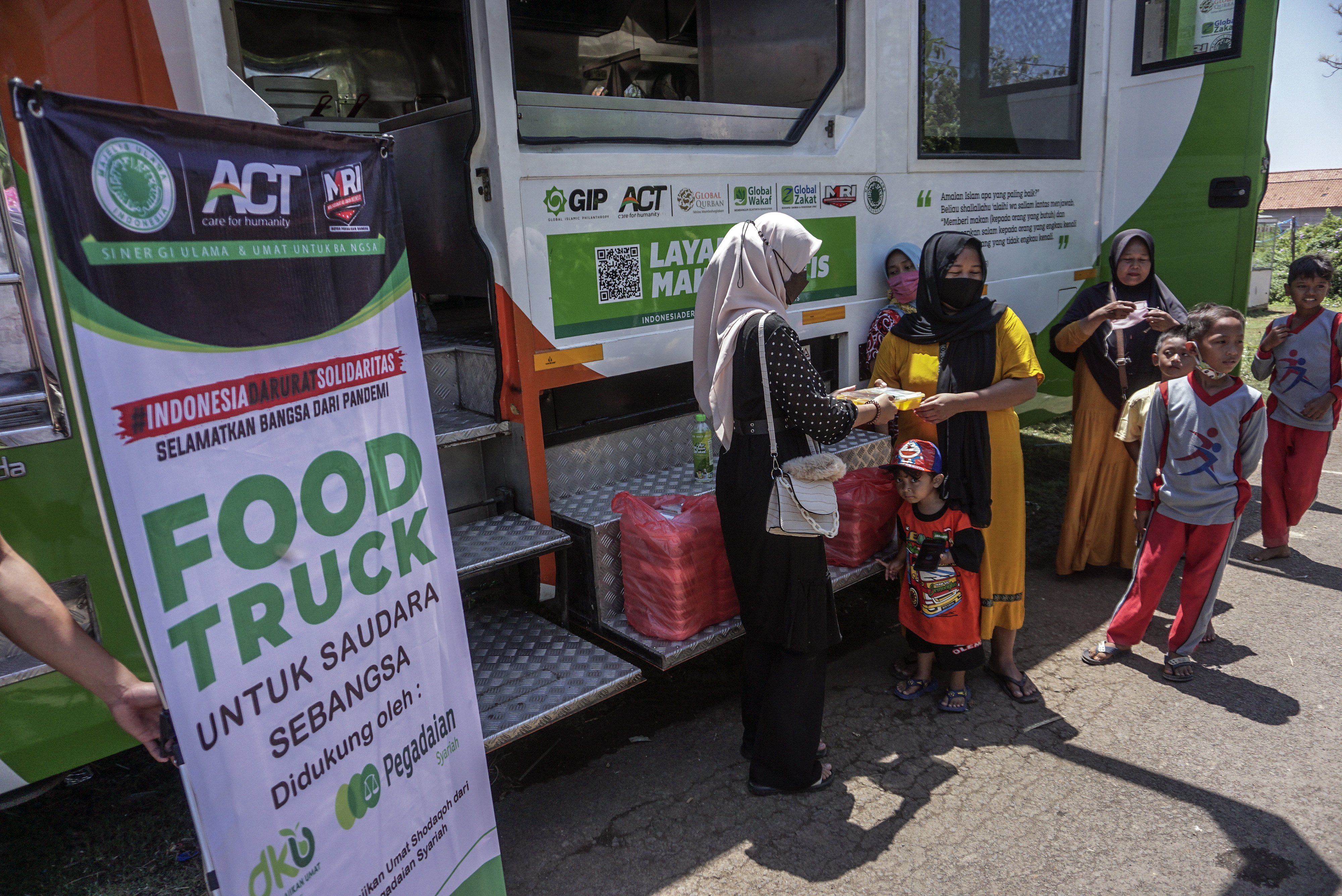  Sejumlah warga antre mengambil bantuan makanan dari Aksi Cepat Tanggap di Pekalongan, Jawa Tengah. 