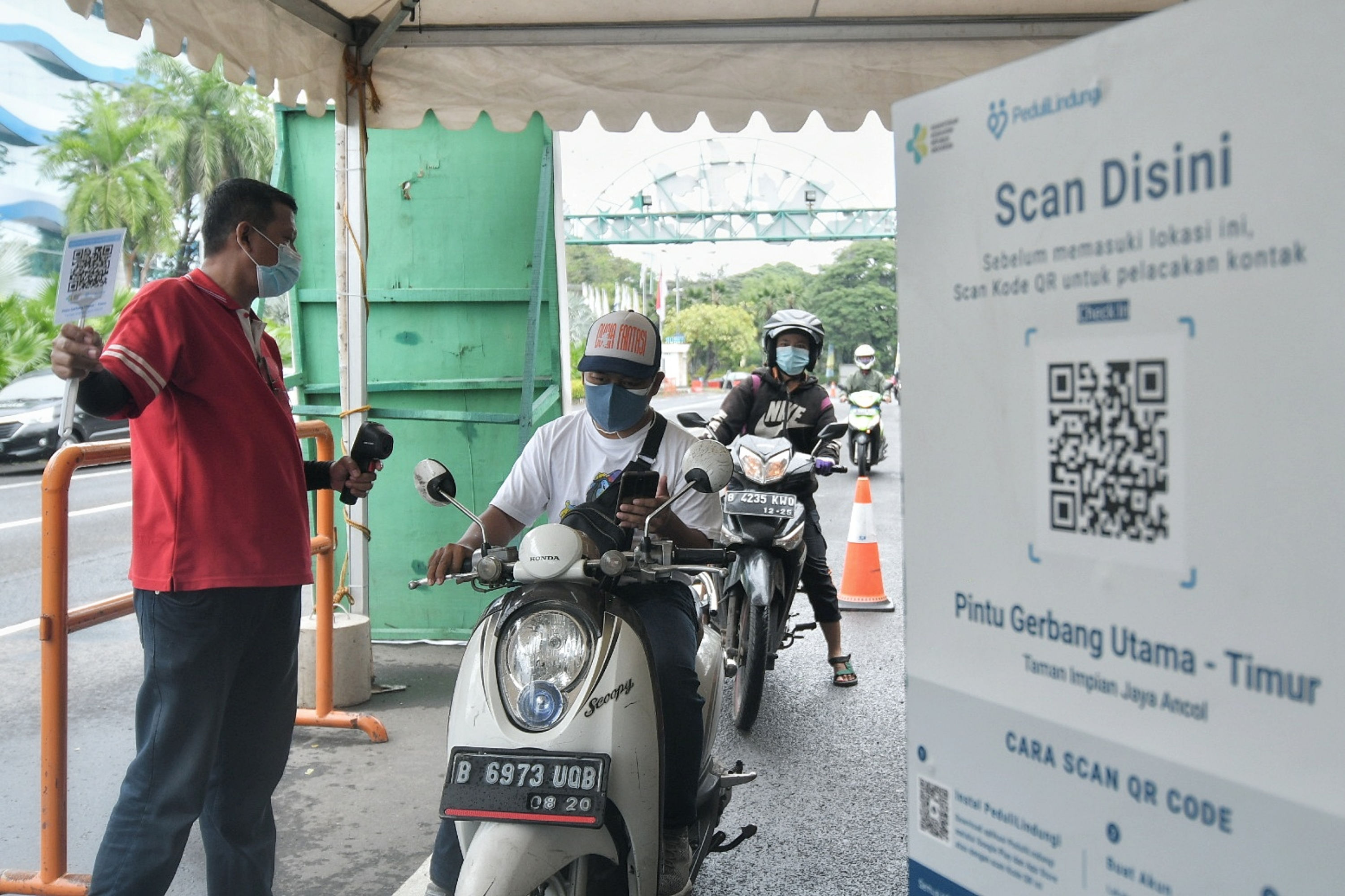 Pengunjung memindai kode QR melalui aplikasi Peduli Lindungi di Pintu Gerbang Taman Impian Jaya Ancol, Jakarta, Selasa (14/9/2021).