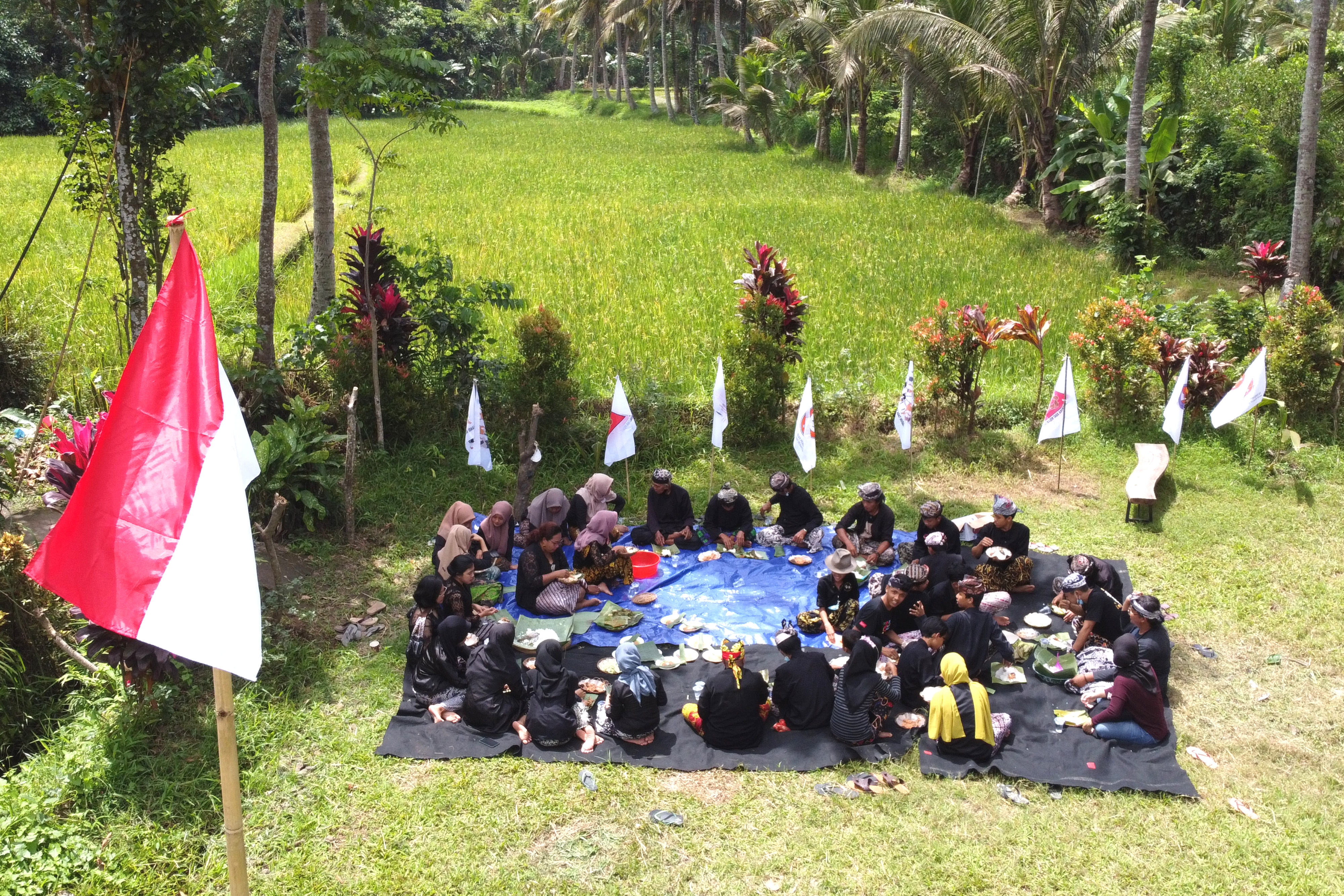 Warga Suku Osing makan bersama saat menggelar tradisi Mocoan Lontar di Pesinauan Desa Adat Kemiren, Banyuwangi, Jawa Timur, Agustus 2021.