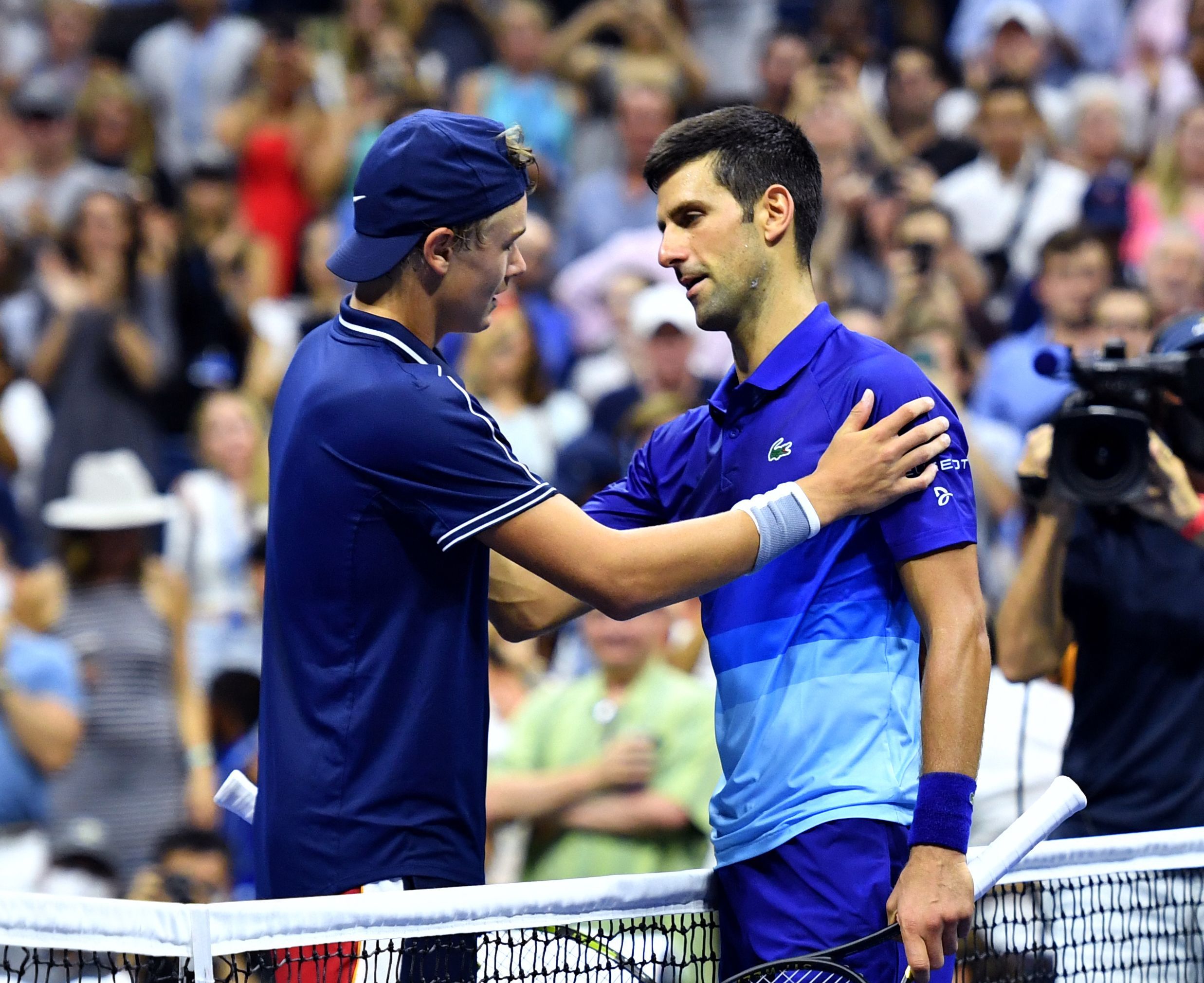 Seusai memenangi laga, Novak Djokovic (kanan) memberi salam kepada lawannya, Holger Rune, dari Denmark. 