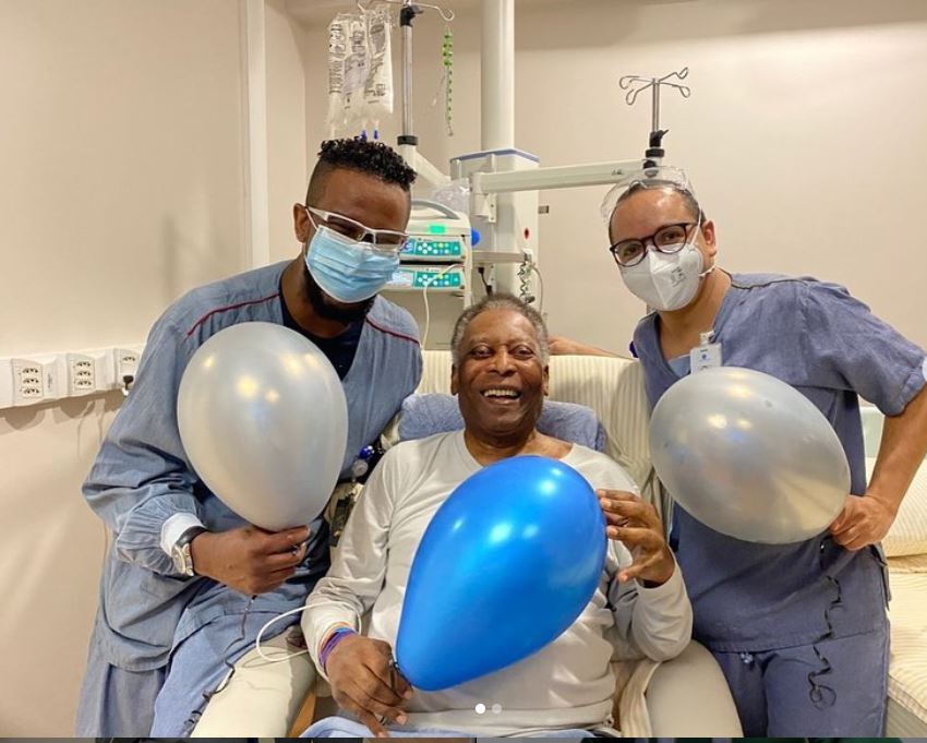 Legenda sepak bola Brasil Pele berpose dengan dua perawatnya di rumah sakit.
