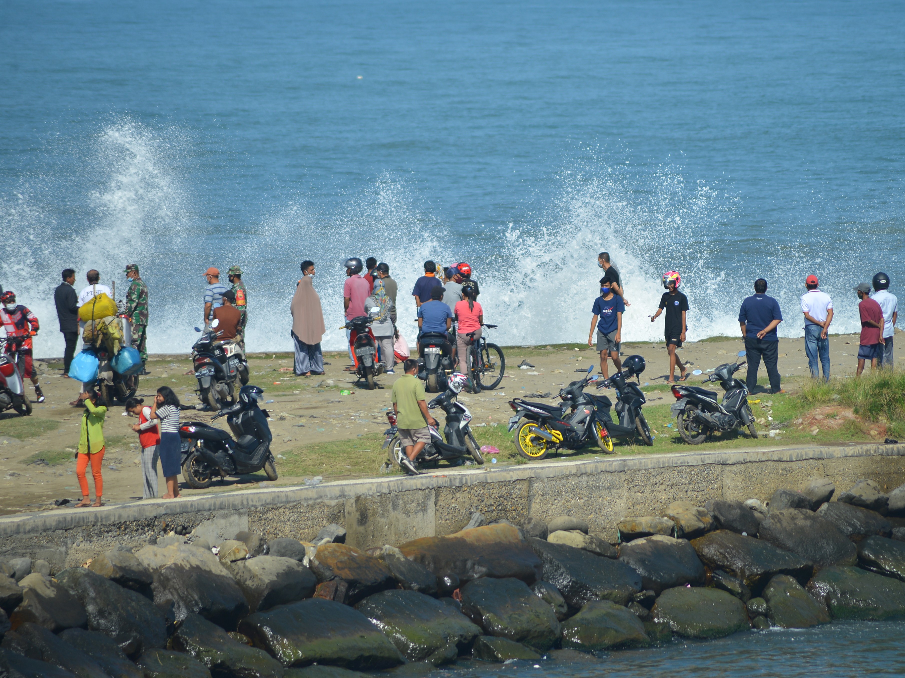 Warga melihat ombak menerjang batu grip di Pantai Purus, Padang, Sumatera Barat, Sabtu (11/9).