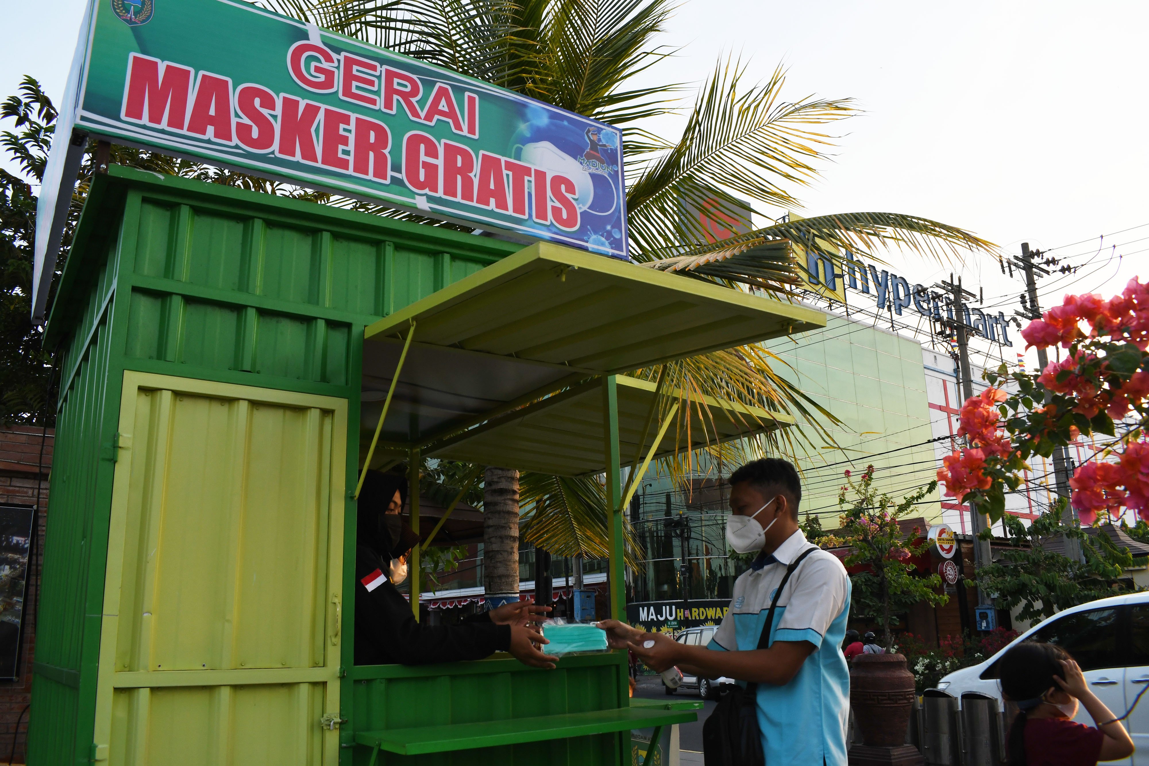  Petugas memberikan masker medis kepada warga di gerai masker gratis Kota Madiun, Jawa Timur, Kamis (2/9/2021)