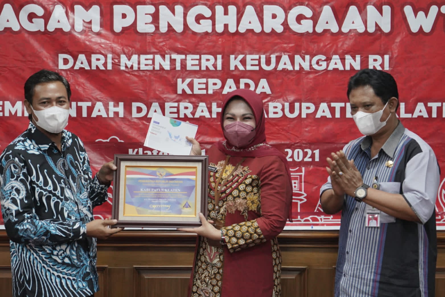  Kepala Kantor Pelayanan Perbendaharaan Negara Klaten Taufiq Widyantoro menyerahkan penghargaan Menteri Keuangan kepada Bupati Sri Mulyani. 