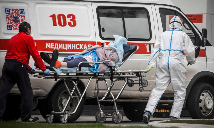 Seorang pekerja medis menurunkan seorang pasien covid-19 di sebuah rumah sakit di Moskow, Rusia.