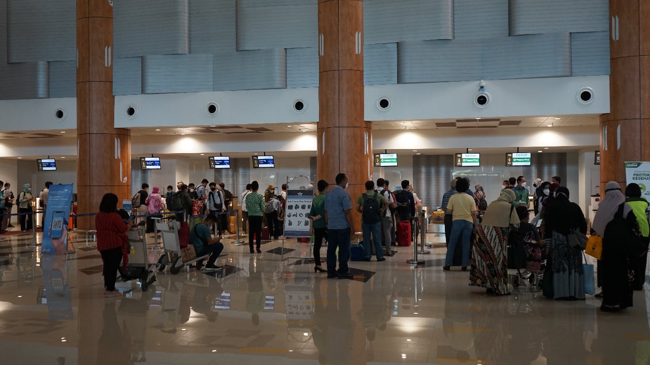 Calon penumpang di Bandara Juanda Jawa Timur mengantri di depan loket pelayanan.