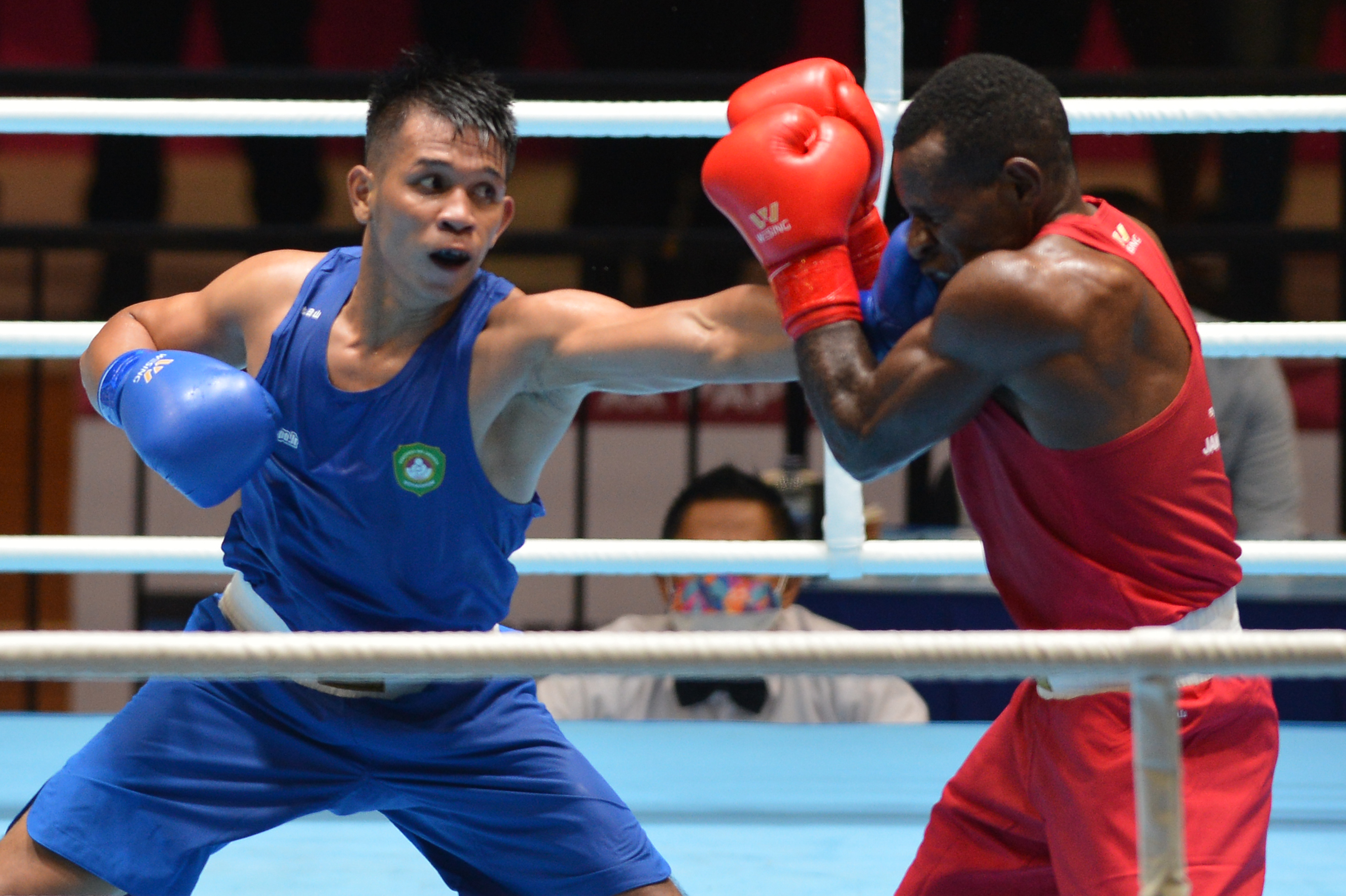 Laga tinju PON XX Papua babak delapan besar antara Petinju DKI Jakarta Michael Ronaldo (kiri) dan petinju Jawa Timur Mendy Yikwa.  