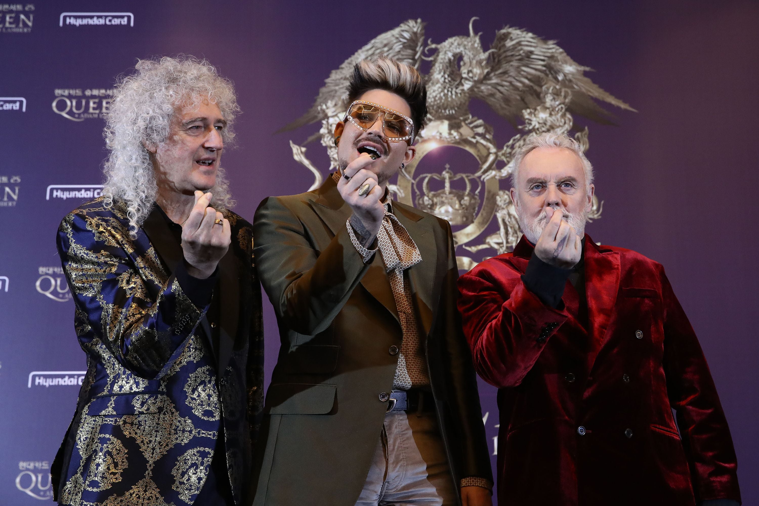 Adam Lambert (tengah) diapit dua personel Queen Brian May (kanan) dan Roger Taylor.