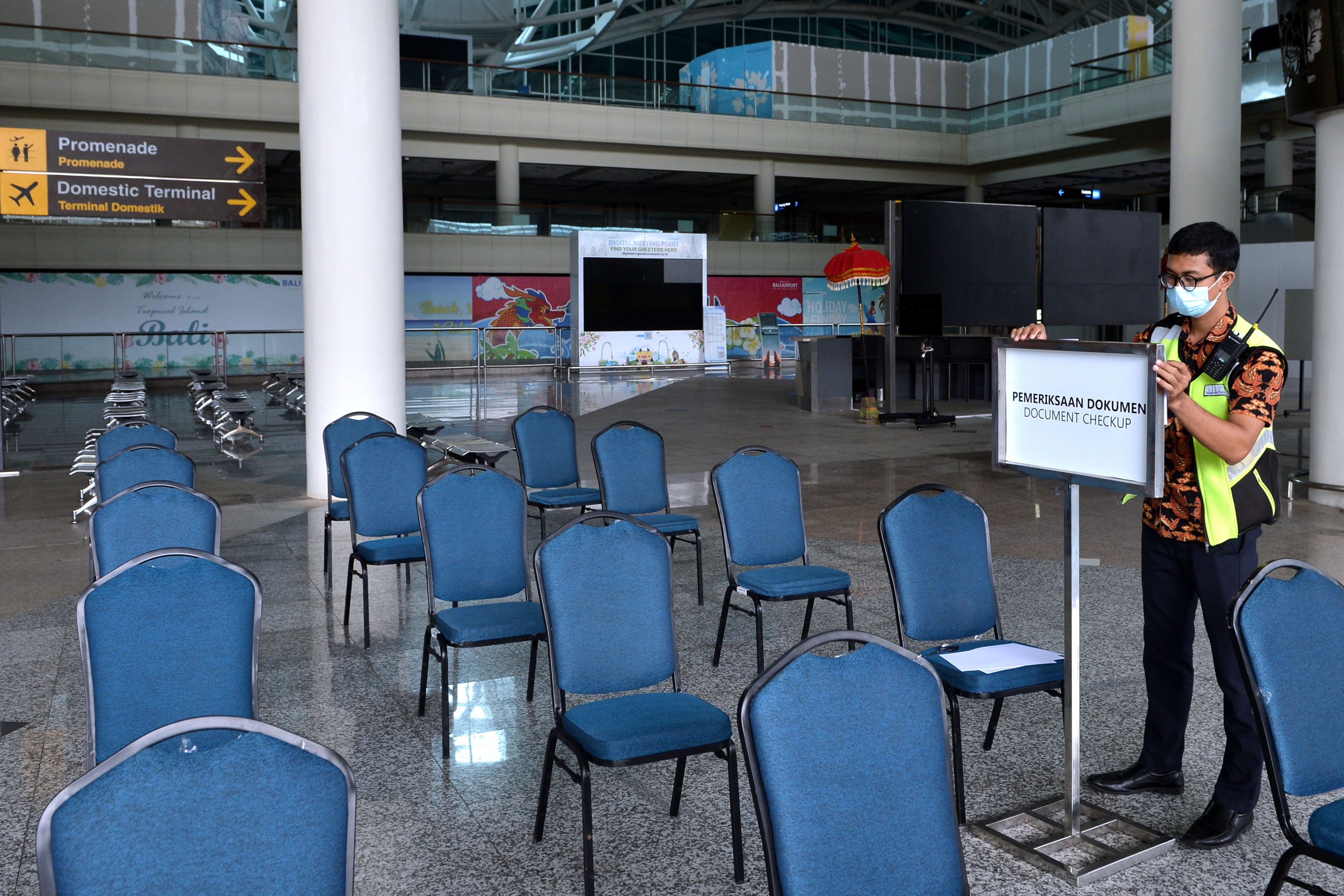 Petugas menyiapkan holding area bagi kedatangan penumpang penerbangan internasional di Bandara I Gusti Ngurah Rai, Bali, Selasa (5/10).