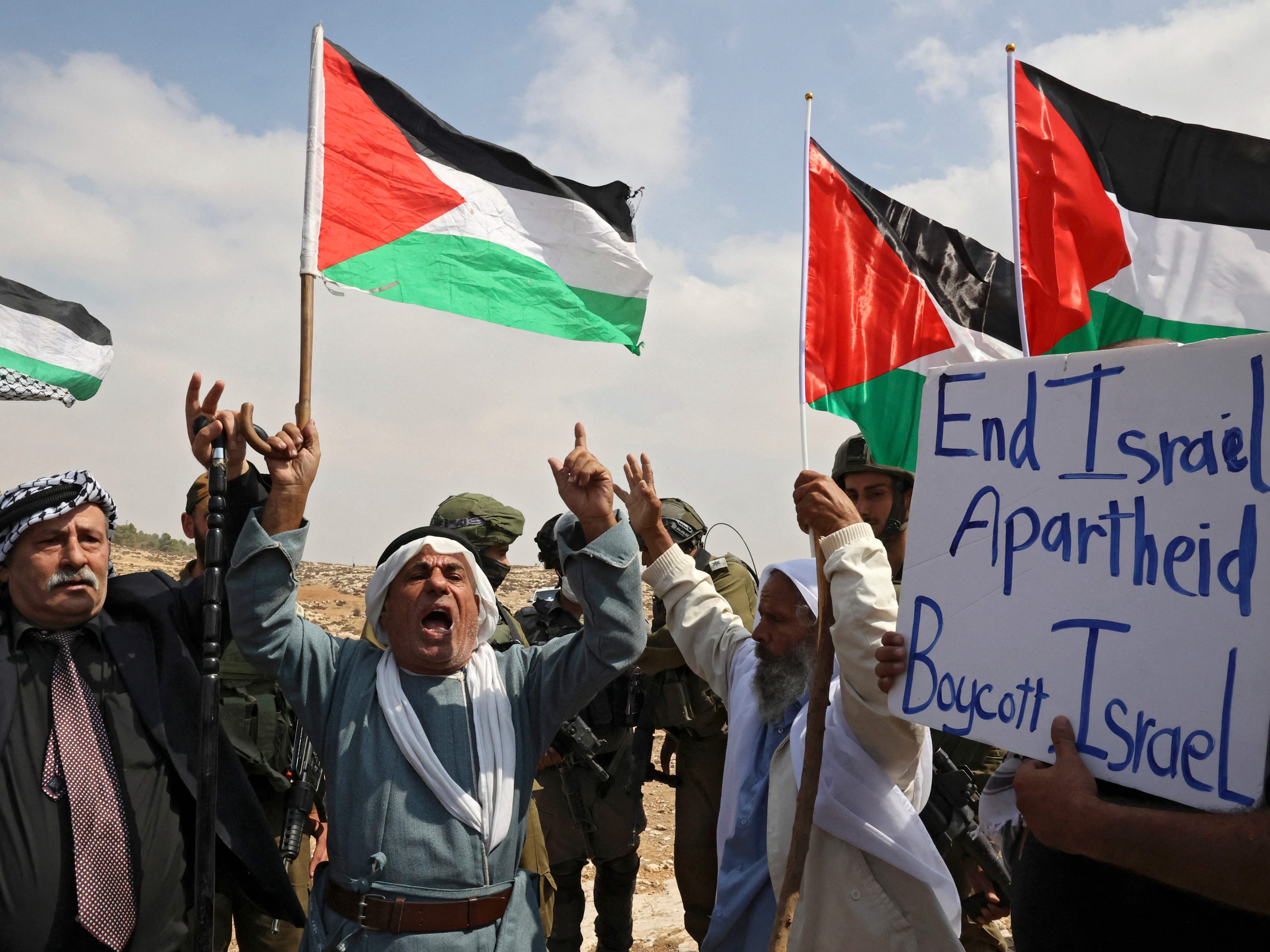 Demonstran lansia Palestina meneriakkan slogan-slogan di depan tentara Israel selama demonstrasi menentang perampasan tanah oleh Israel.