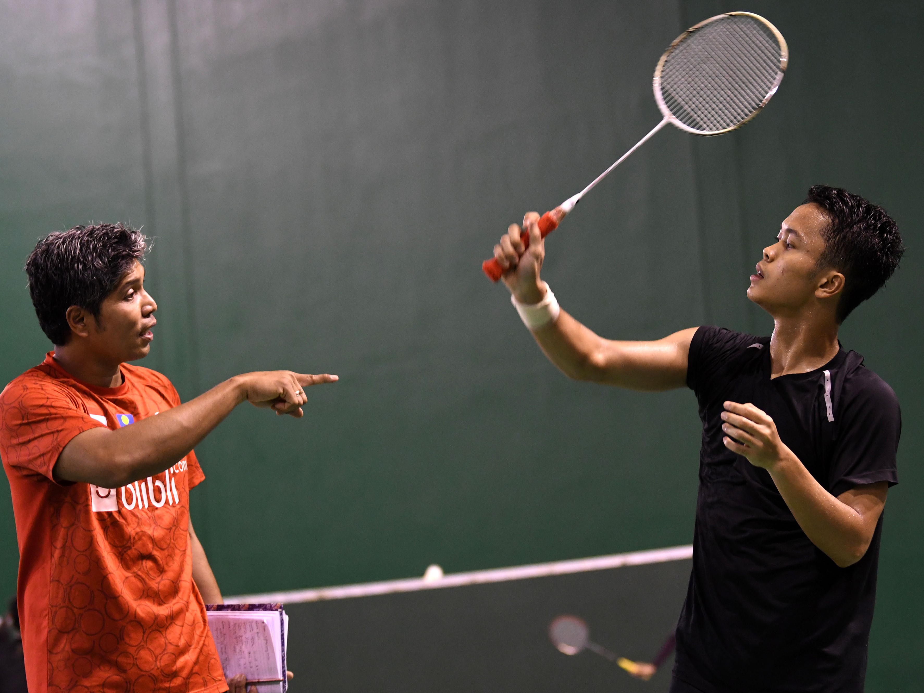 Pebulu tangkis Anthony Sinisuka Ginting (kanan) berdiskusi dengan asisten pelatih Irwansyah saat berlatih, beberapa waktu lalu.