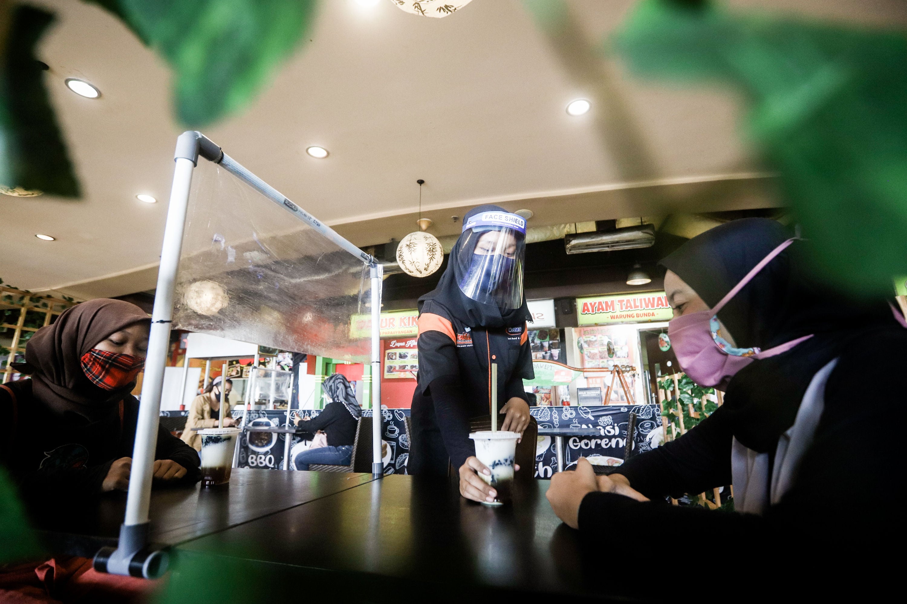 Petugas menyajikan makanan di restoran mal Bekasi Cyber Park , Jawa Barat.