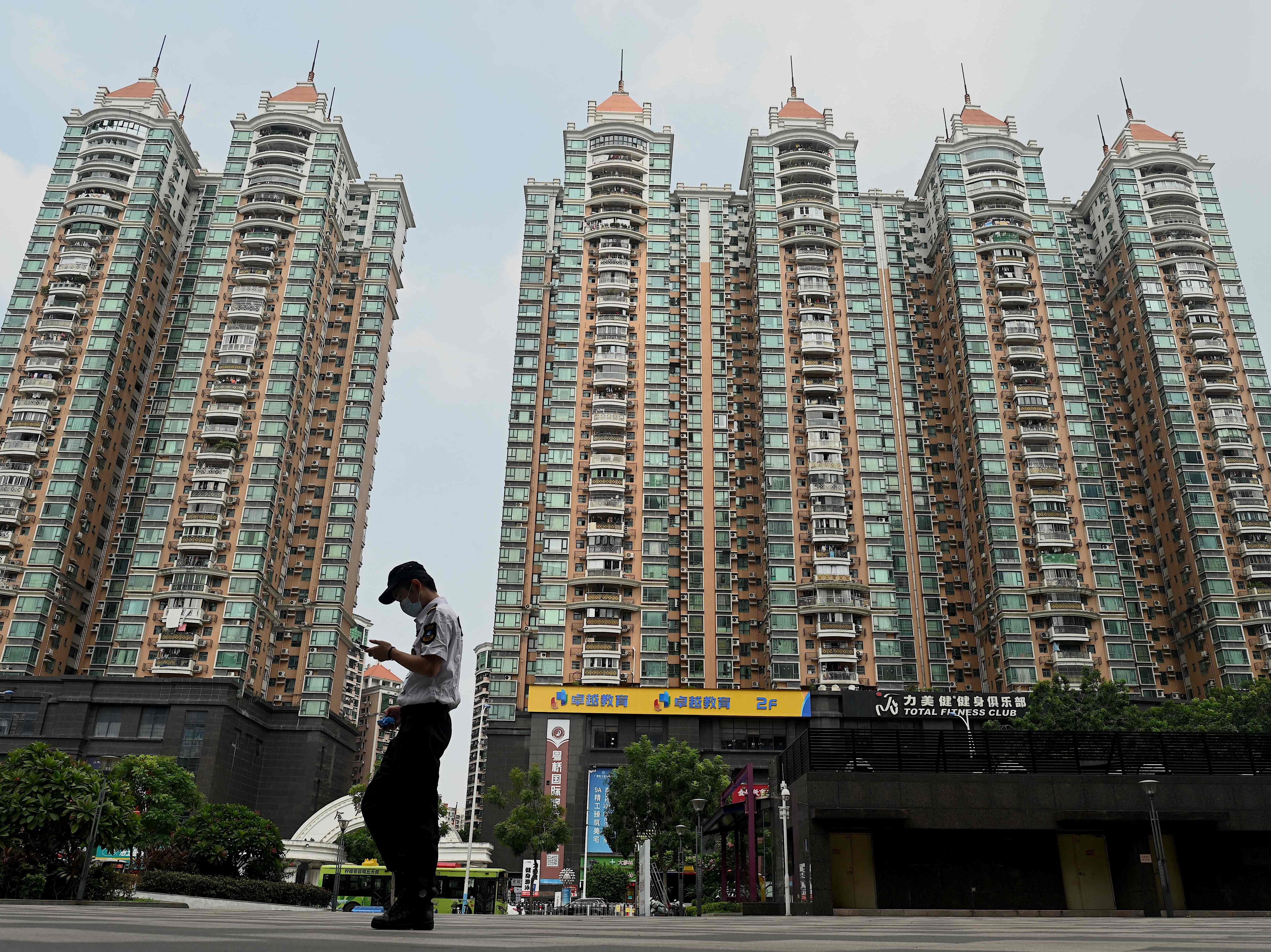 Seorang pria berjalan melewati kompleks perumahan milik pengembang China Evergrande di Guangzhou, provinsi Guangdong selatan Tiongkok.