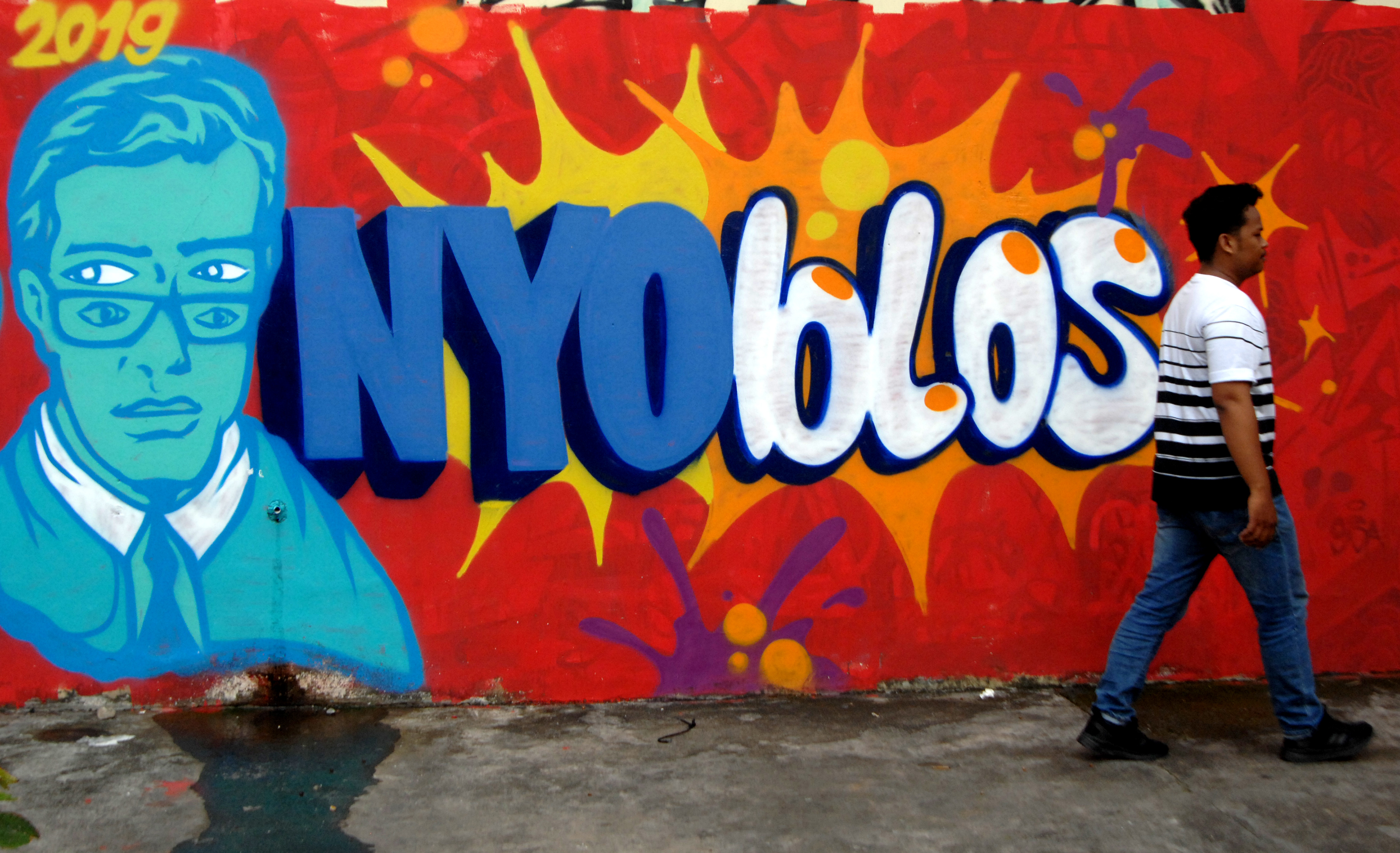 Ilustrasi warga melintas di depan mural tentang pemilu pada 2019 lalu.