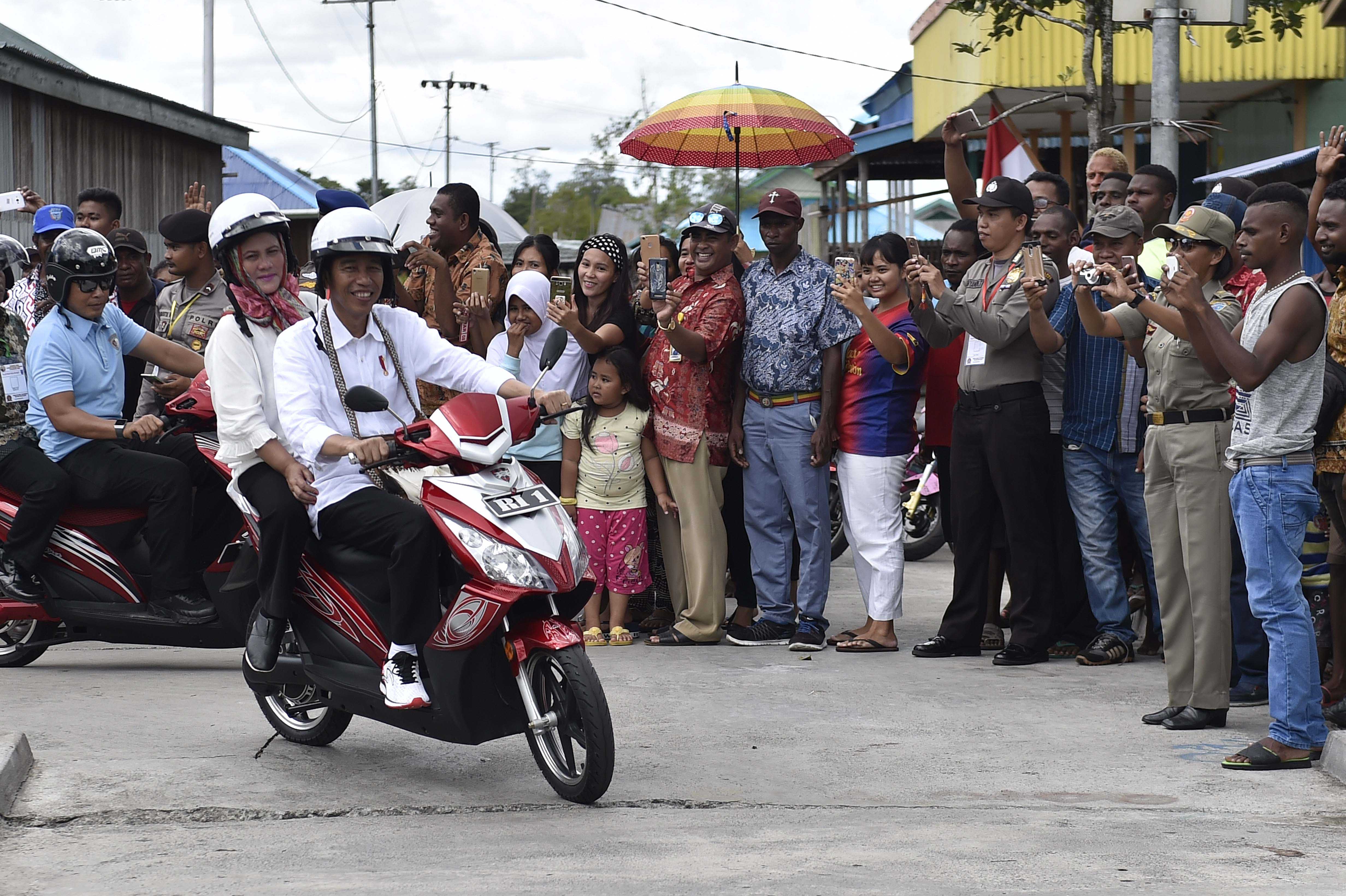 Presiden Jokowi berboncengan dengan Ibu Negara saat mengunjungi Distrik Agats, Kabupaten Asmat, Papua.